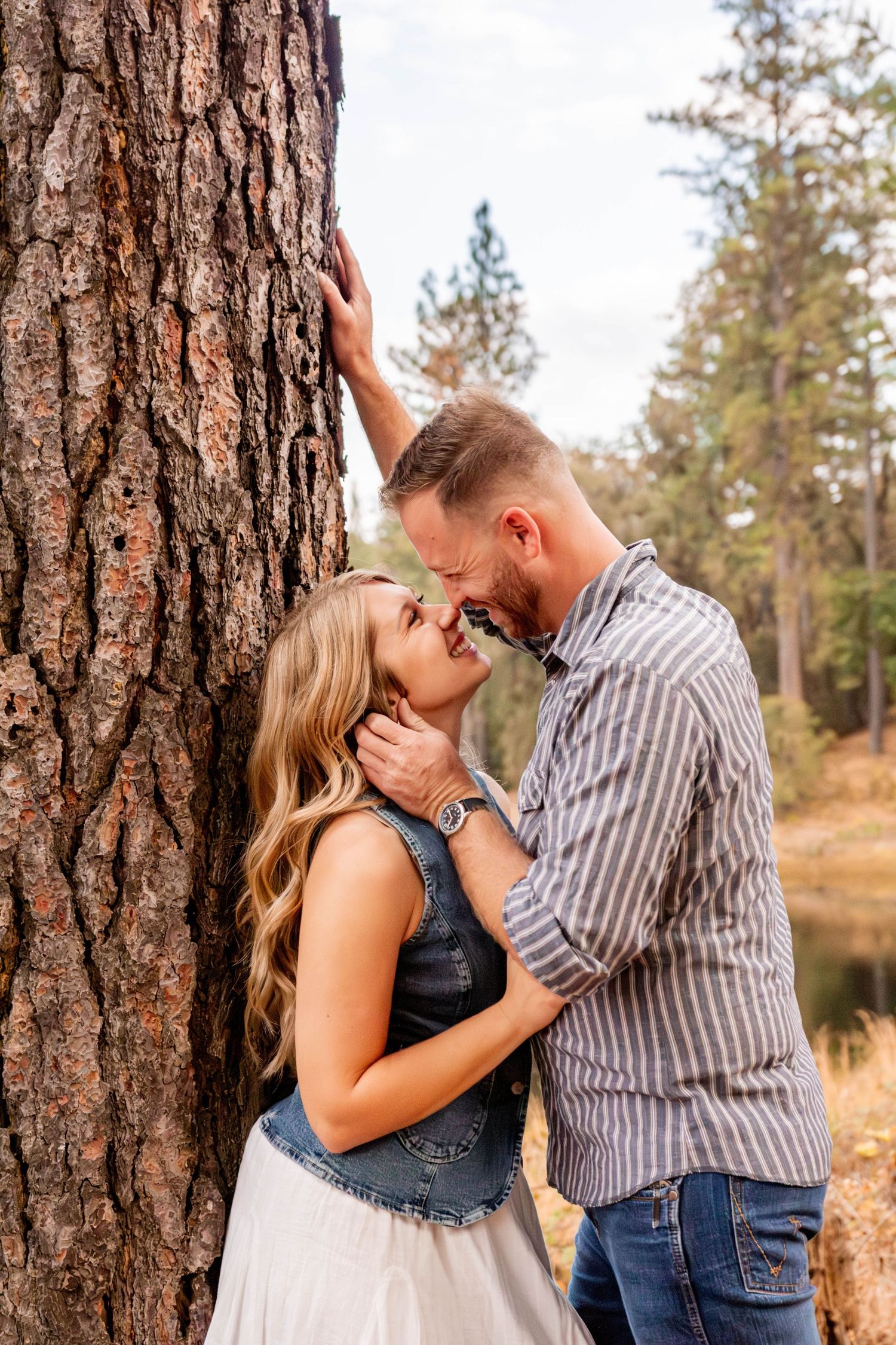man and woman kissing by lake in Pine Grove, California