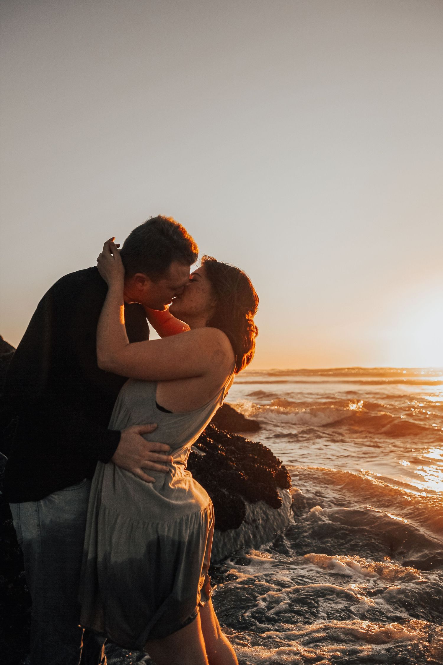 man and woman kiss by rocks in Encinitas, California