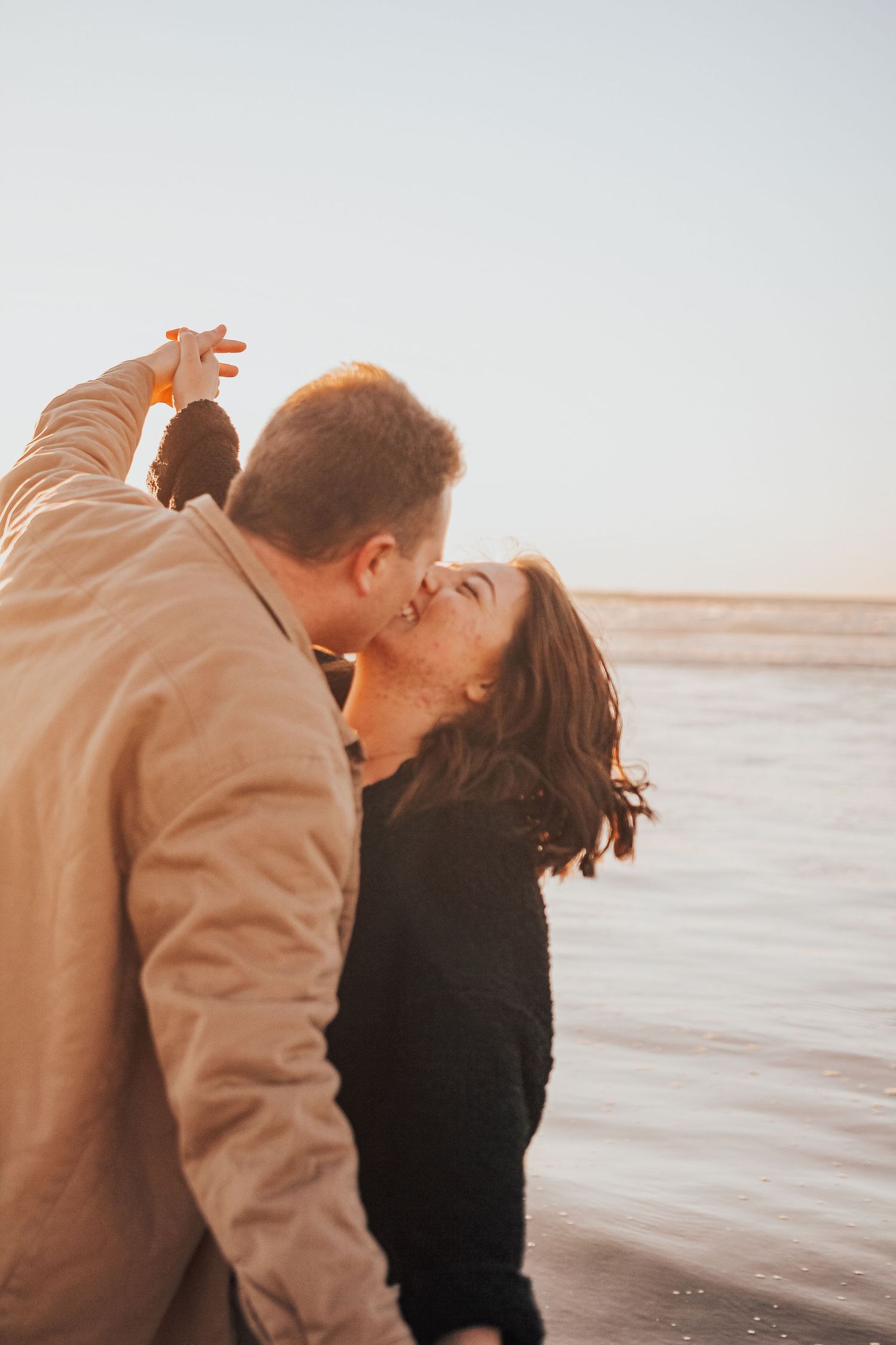 man and woman kissing on beach in Encinitas, California