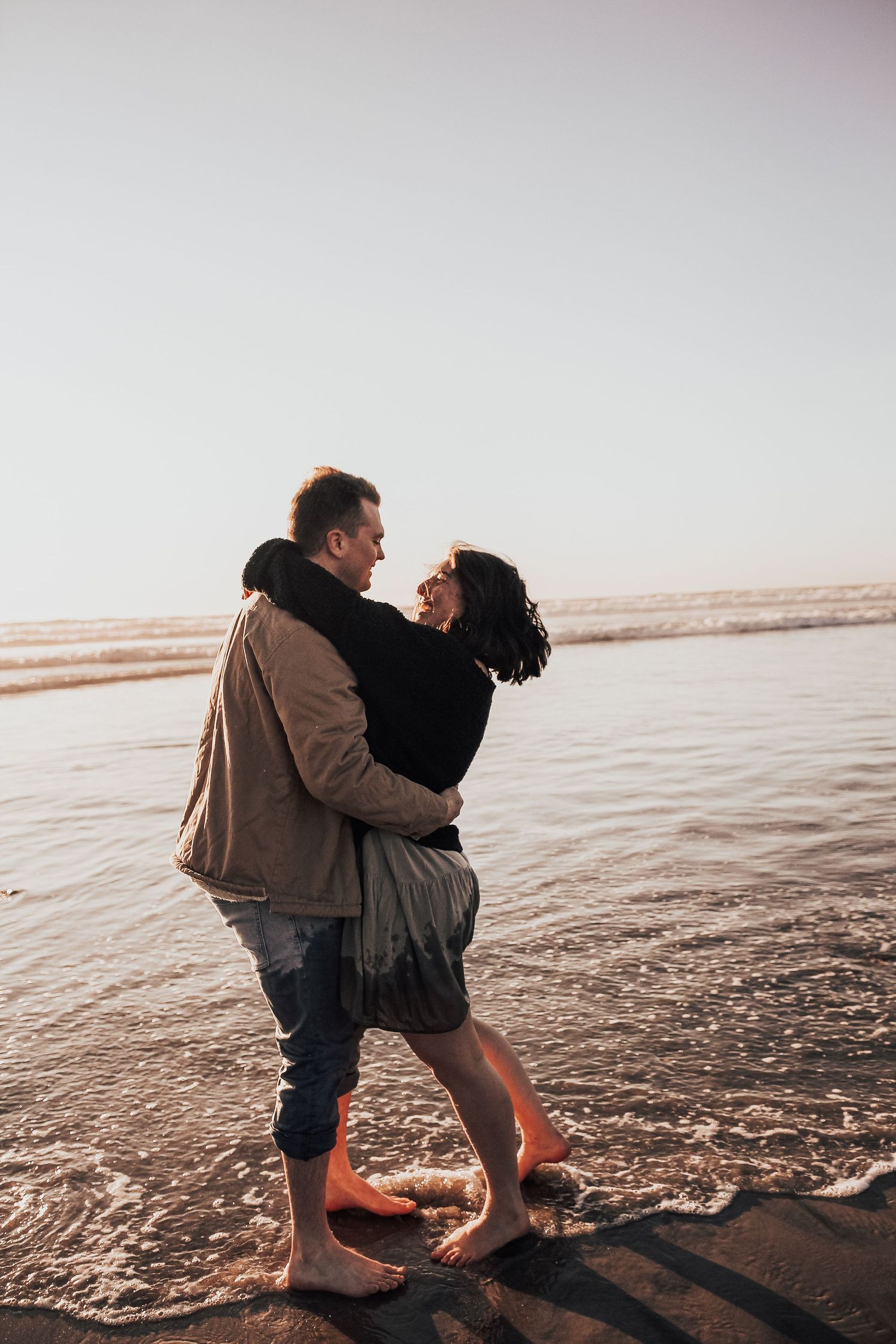 couple hugging on beach in Encinitas, California