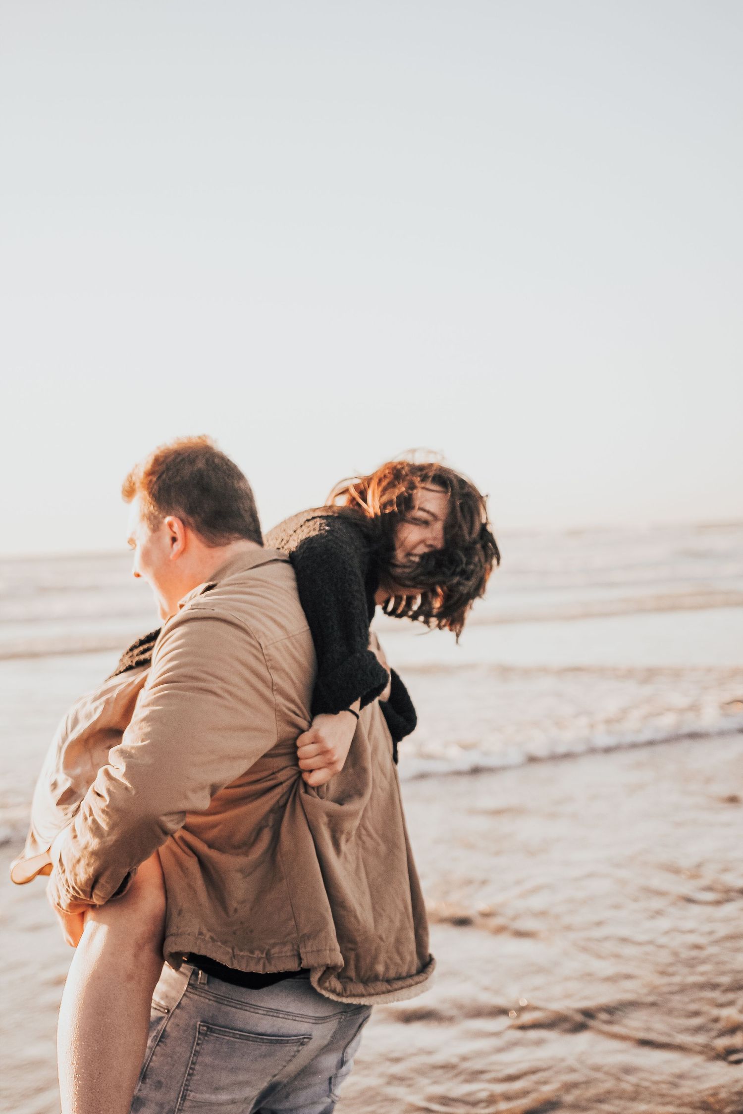 man and woman play by ocean in Encinitas, California
