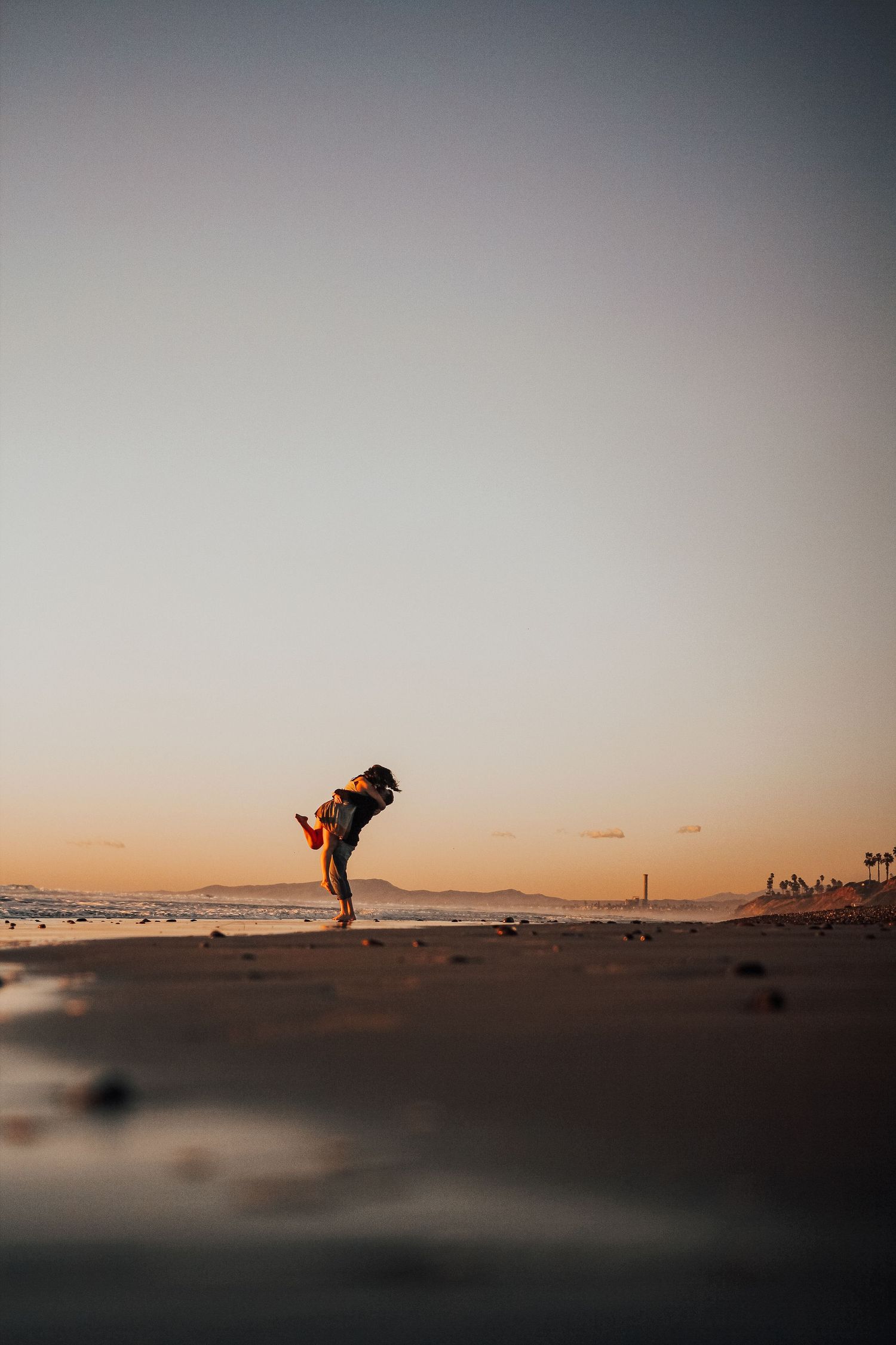 man and woman dance by ocean in Encinitas, California, Oceanside in background