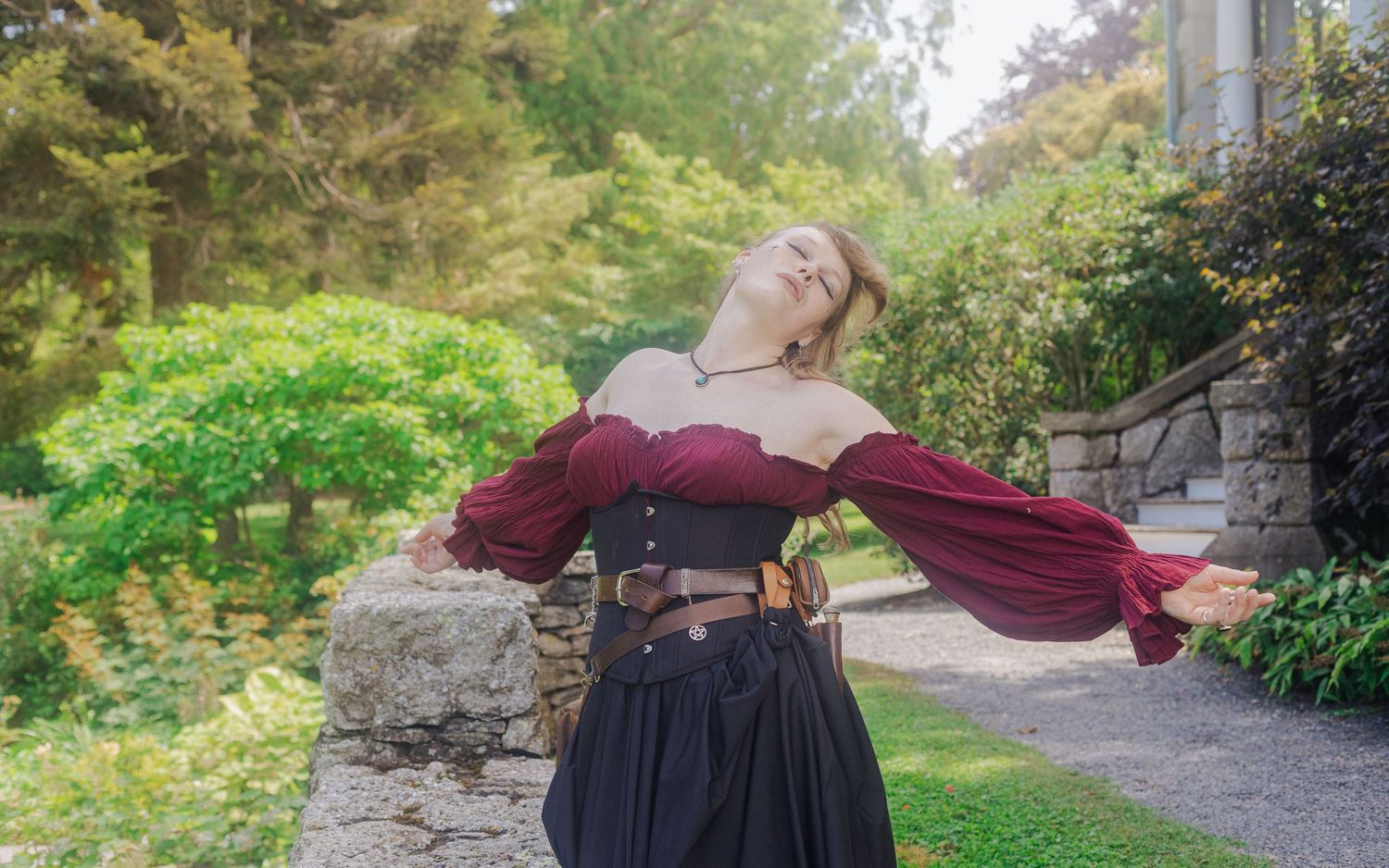 A series of outdoor photos showing a woman in burgundy dress against a natural stone backdrop.