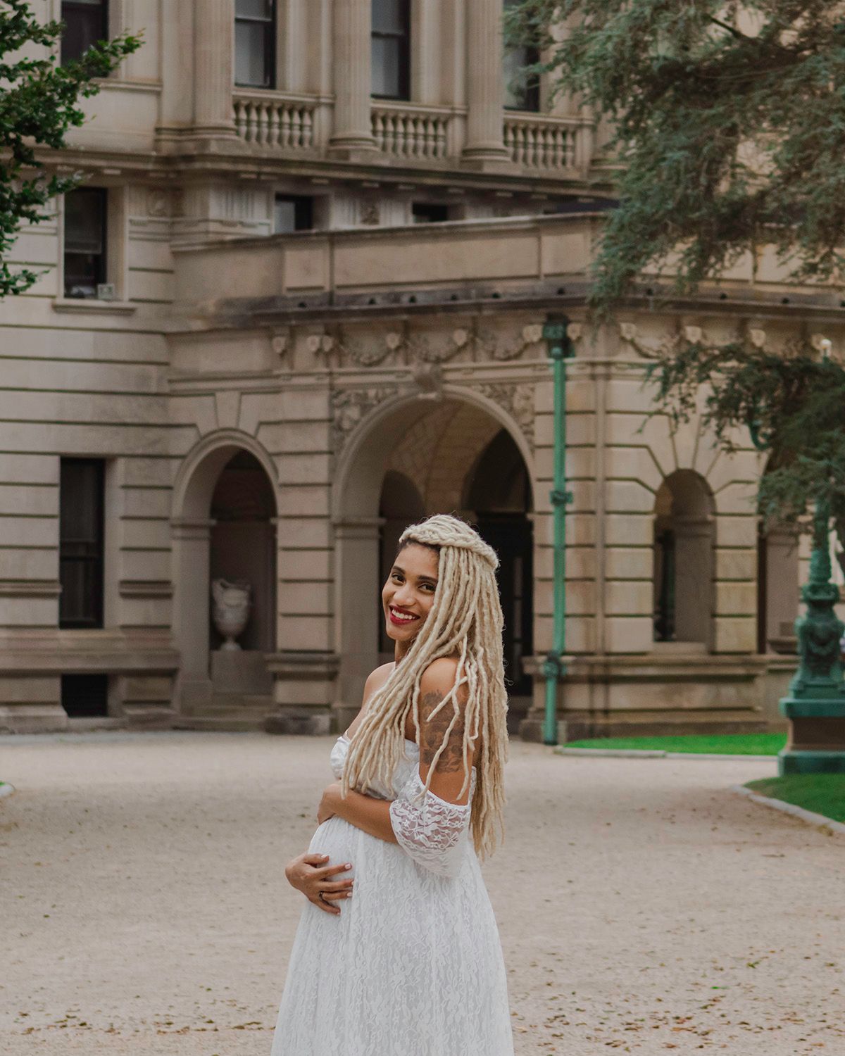 Architectural maternity session featuring stone columns and classical building details.