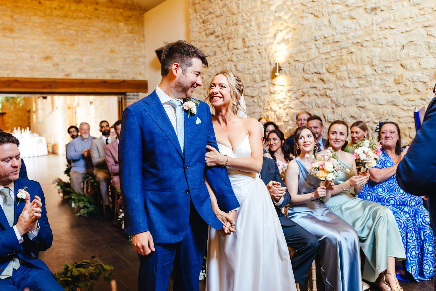 Bride and groom walking into ceremony at Huntsmill Farm barn, relaxed wedding photography