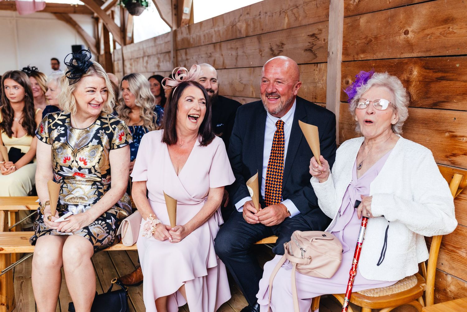 Wedding guests laughing during barn ceremony at Inkersall Grange Farm Derbyshire