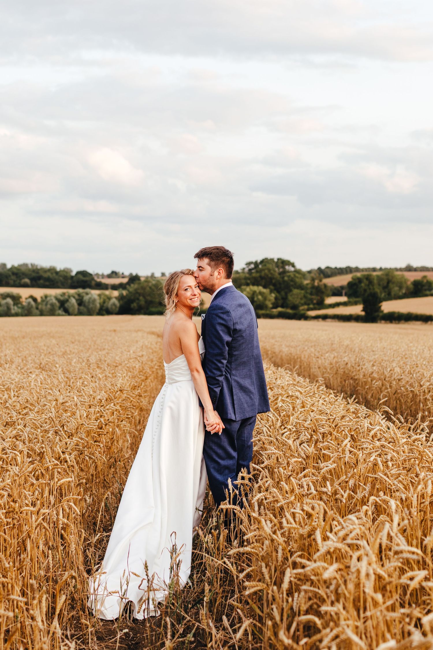 Bride and groom in wheat field at Huntsmill Farm Buckinghamshire, relaxed barn wedding photography
