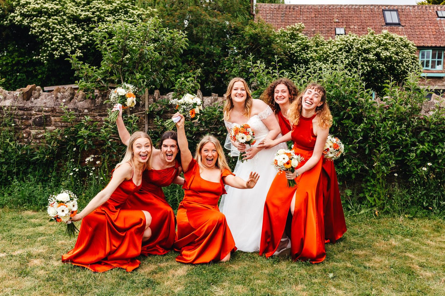 Bridesmaids in orange dresses at Winterbourne Medieval Barn wedding in Bristol