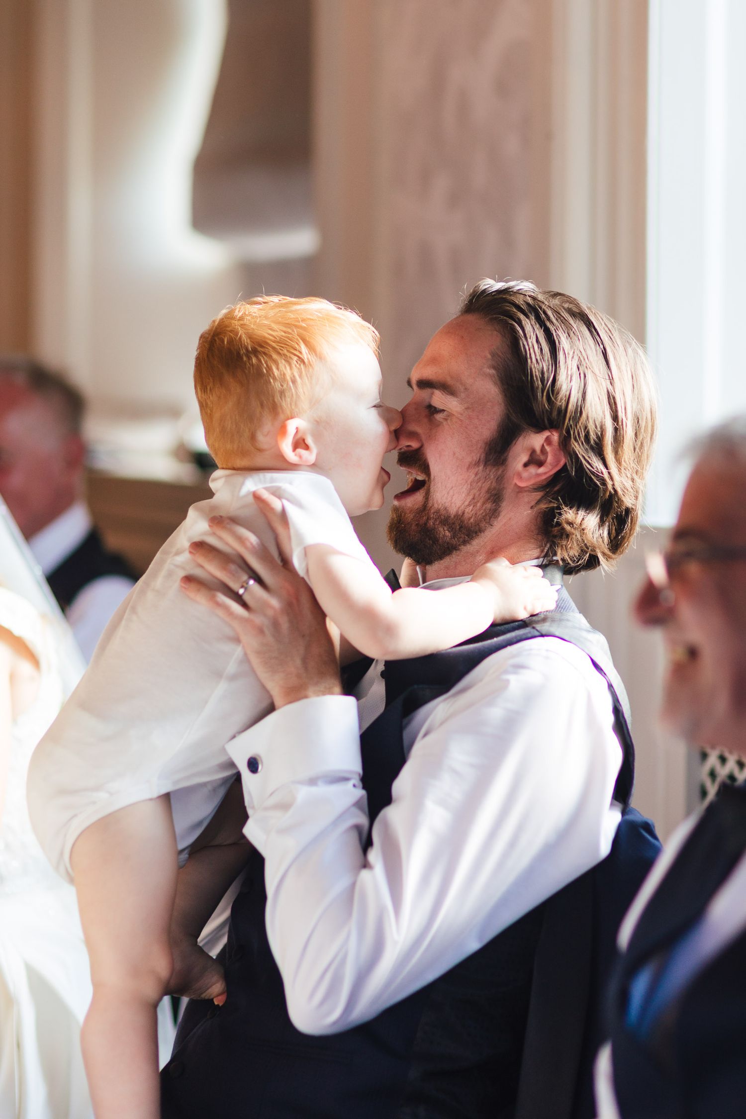 Father holding baby at Barnett Hill Hotel Surrey wedding ceremony, photographed by Derbyshire wedding photographer