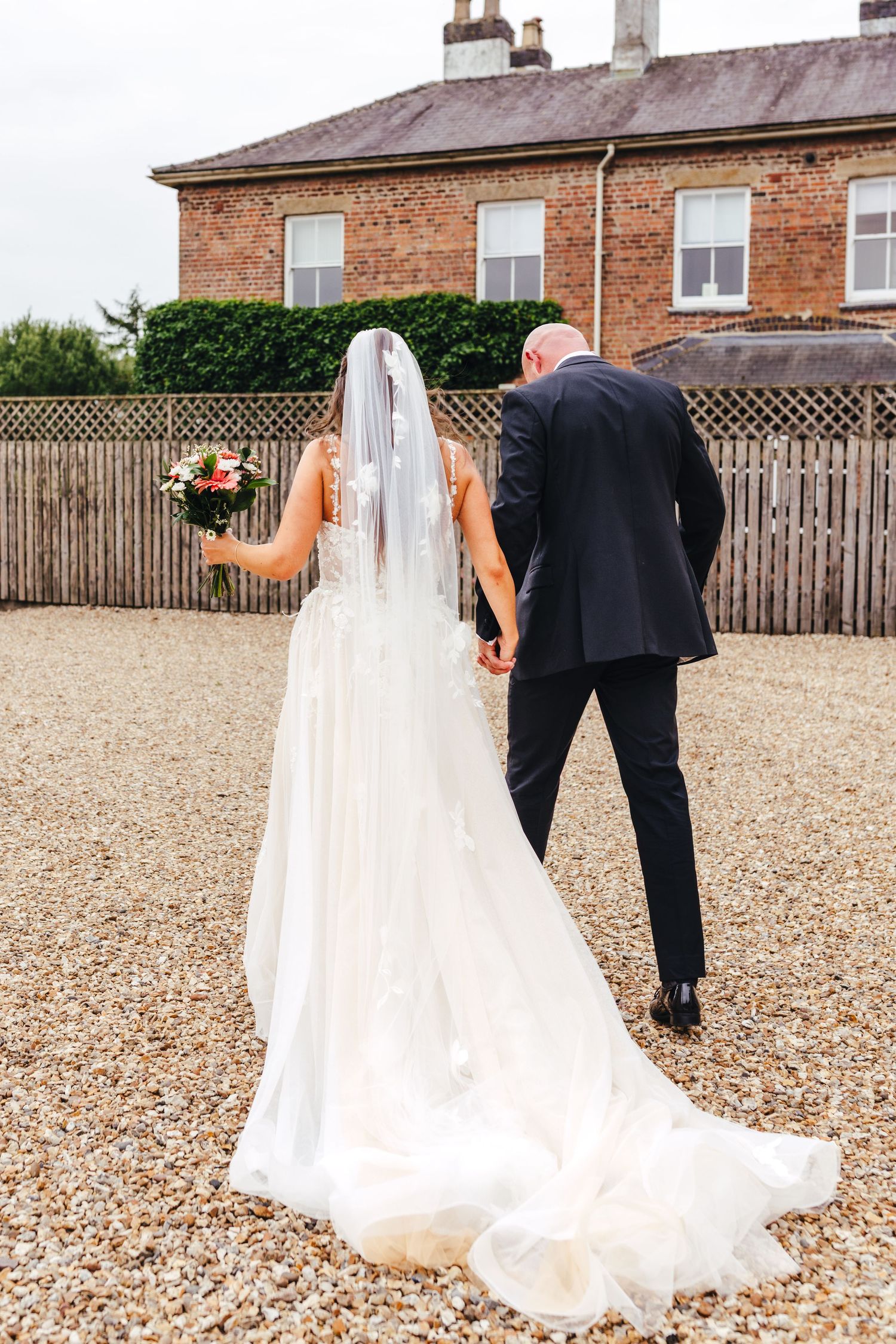 Bride and groom walking across courtyard at Shottle Hall Derbyshire, natural light Derby wedding photography