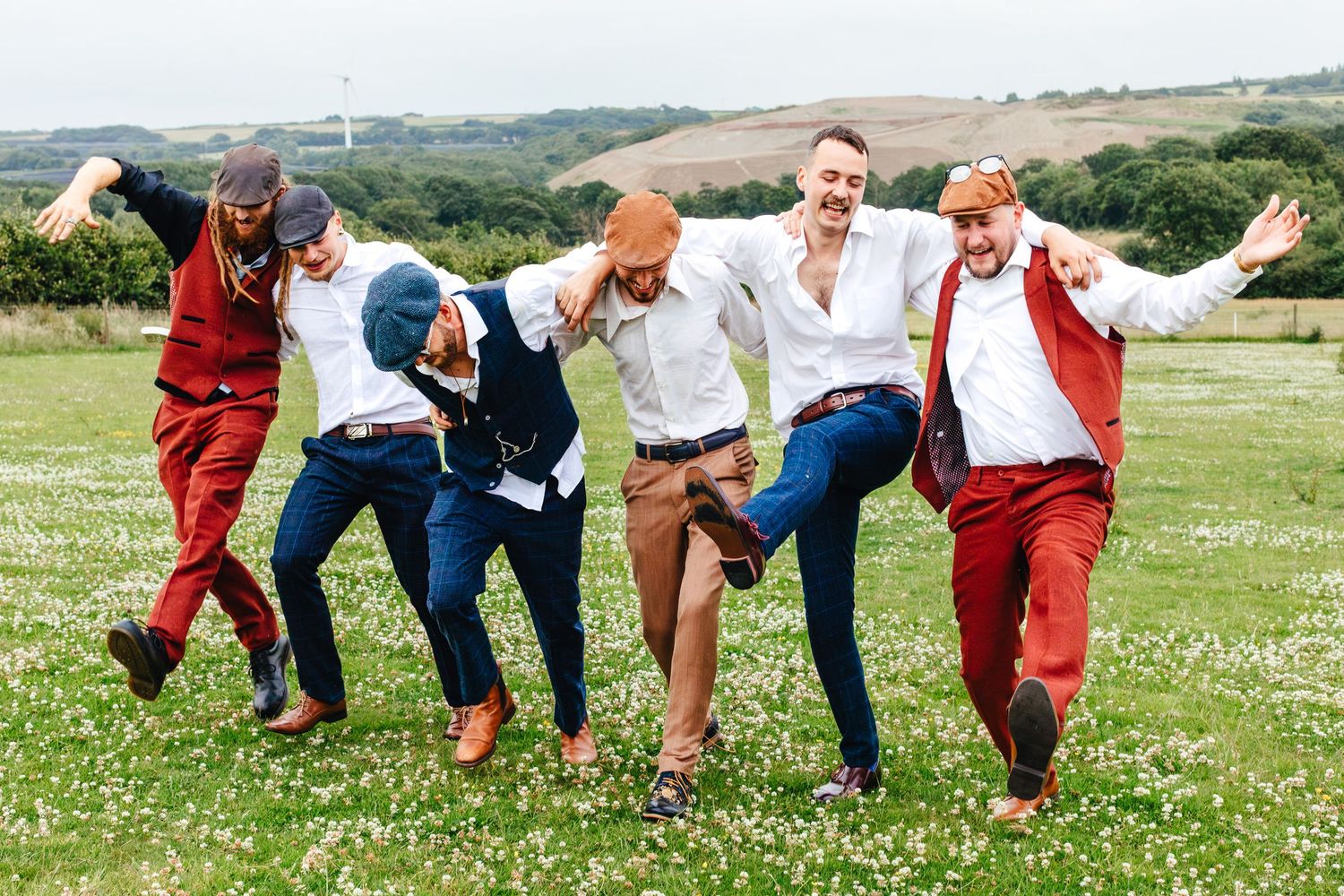 Groomsmen celebrating at Devon countryside farm wedding, relaxed outdoor wedding photography