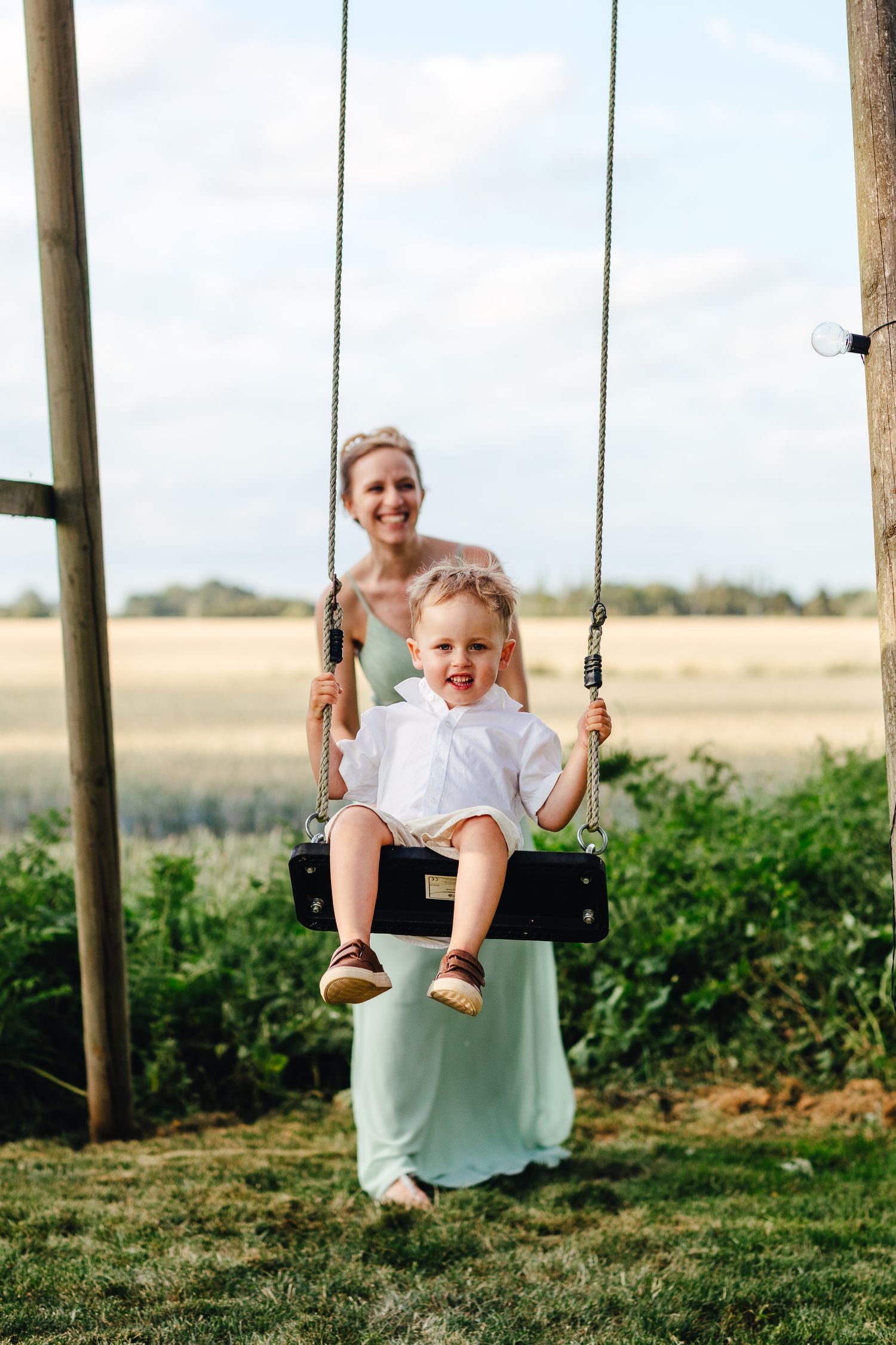 Child on garden swing at Derbyshire wedding, relaxed outdoor countryside wedding photography