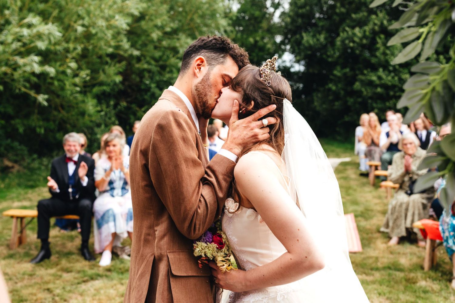 Bride and groom first kiss portrait during outdoor wedding ceremony in Derbyshire