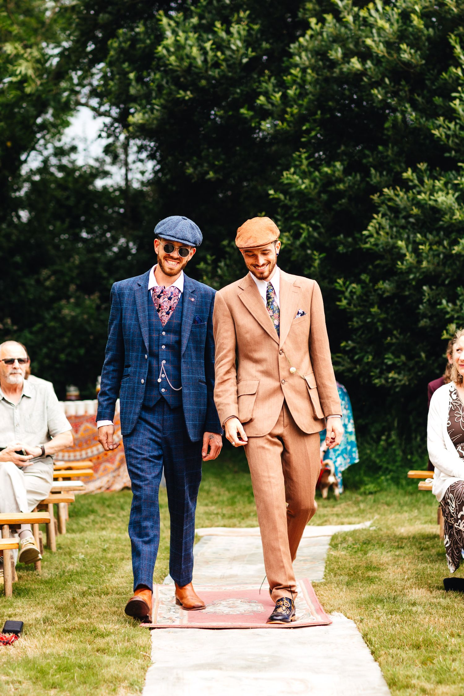 goom and best man walk down the aisle in outdoor Derbyshire wedding ceremony with guests seated on the lawn