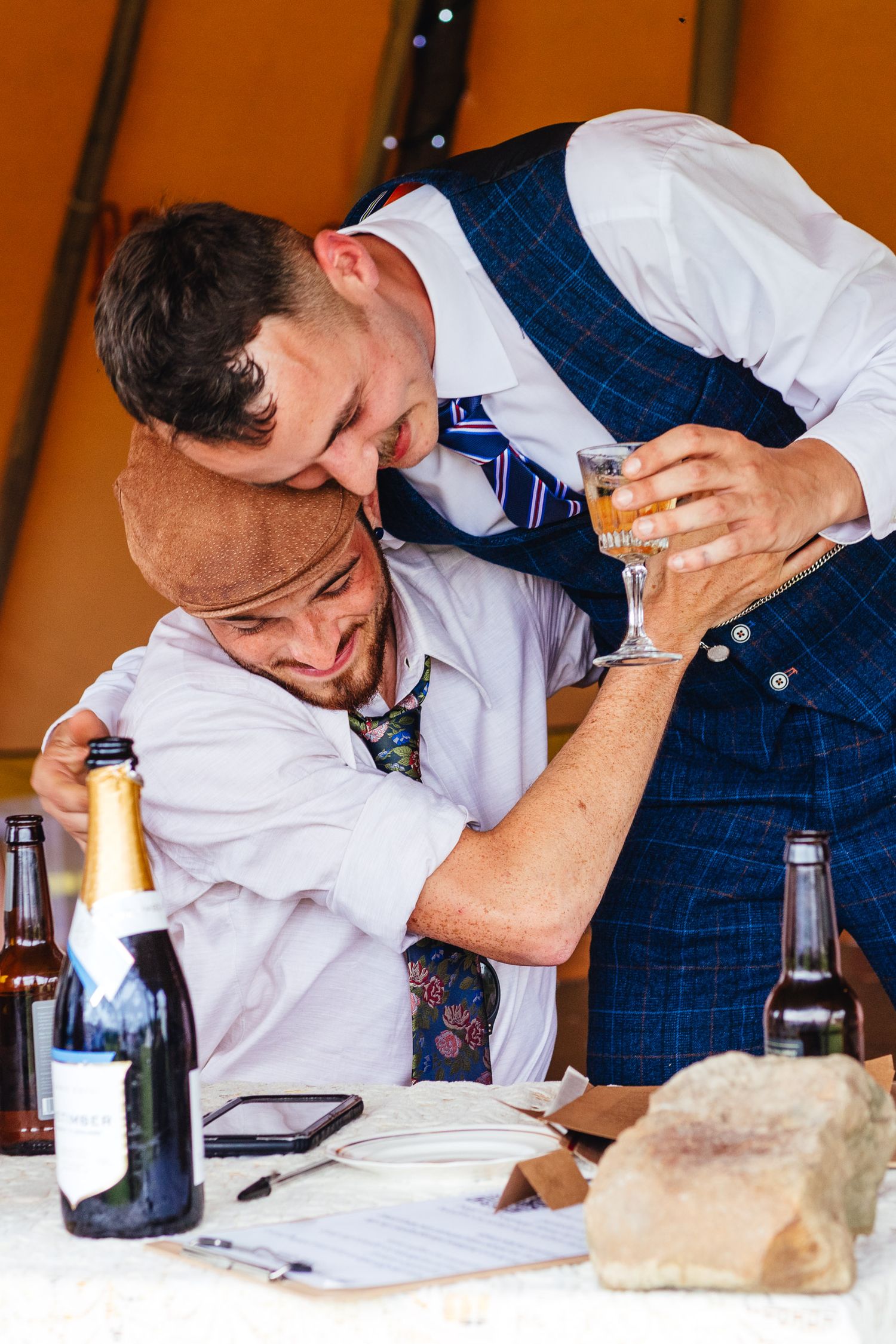 Groom and best man laughing during Derbyshire wedding reception, candid documentary wedding photography