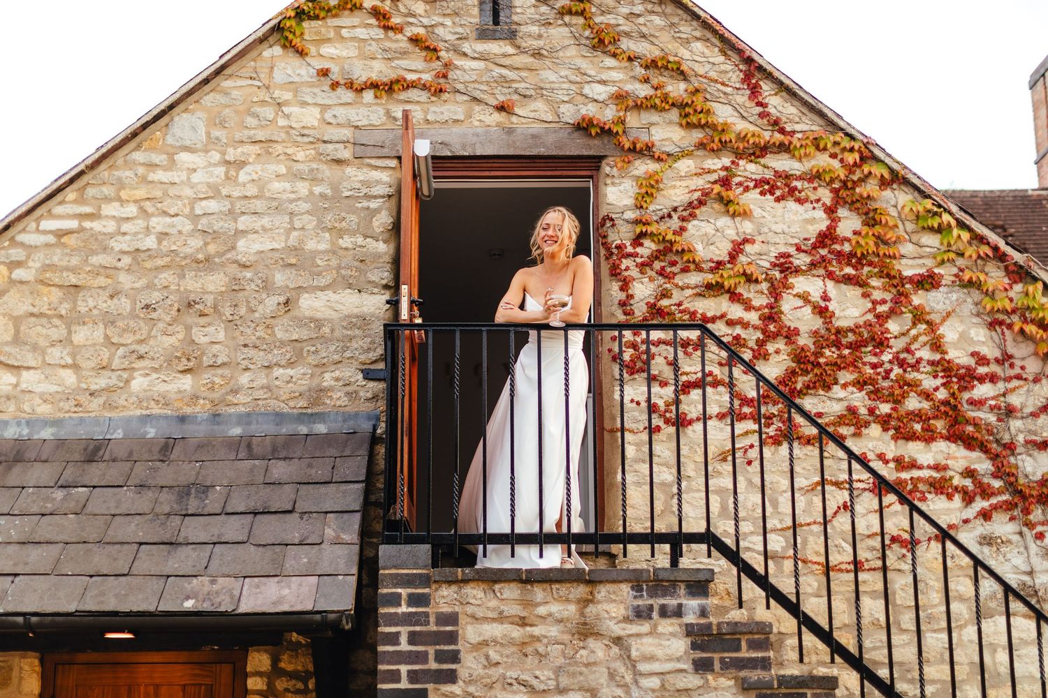 Bride on balcony at Huntsmill Farm barn wedding venue, Buckinghamshire
