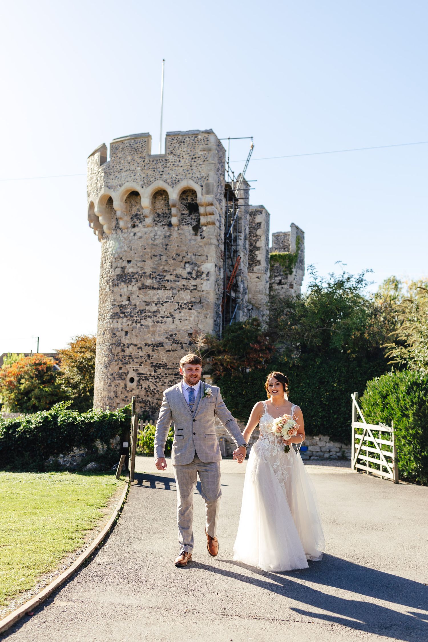 Summer wedding couple portrait at Cooling Castle Barn Kent with historic castle backdrop, relaxed documentary wedding photographer