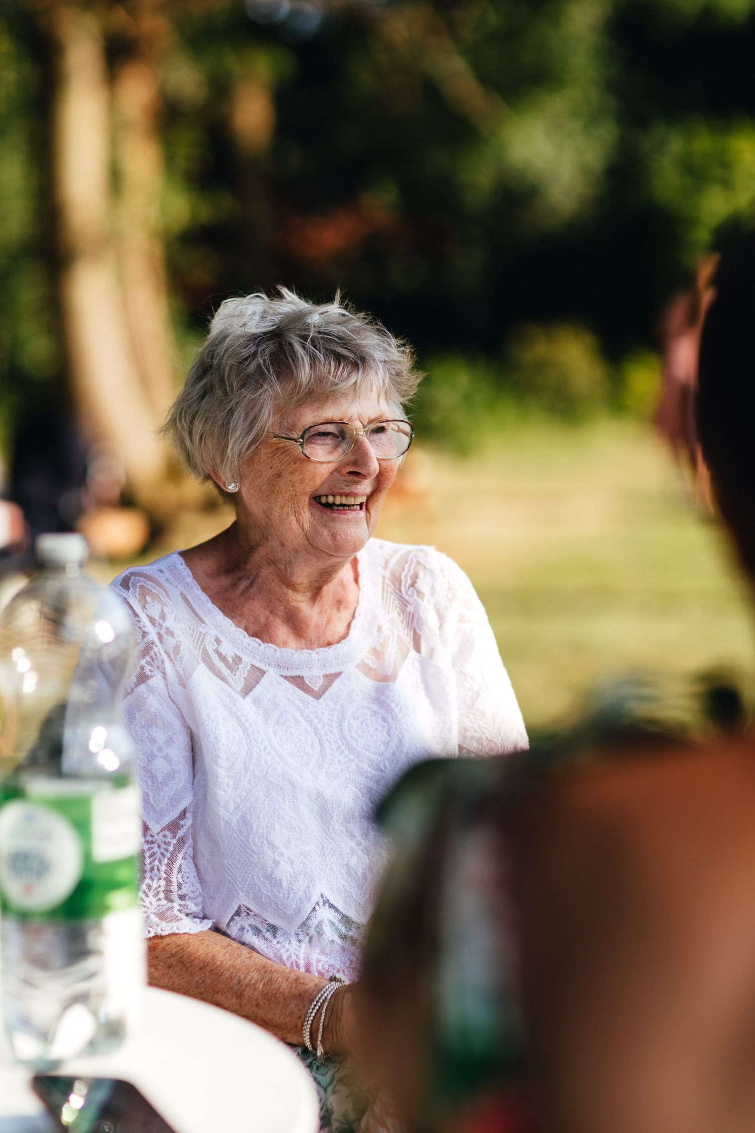 Elderly wedding guest smiling at Derbyshire countryside wedding, natural candid wedding photography