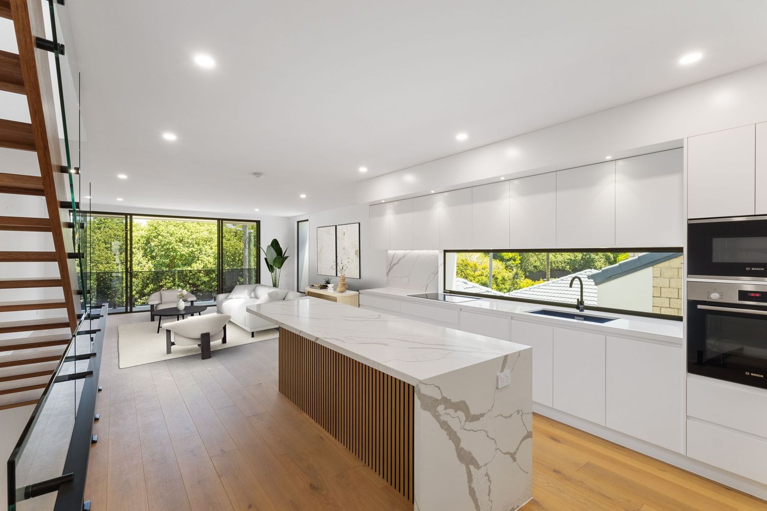 Modern white kitchen interior with marble countertops and sleek cabinetry design.