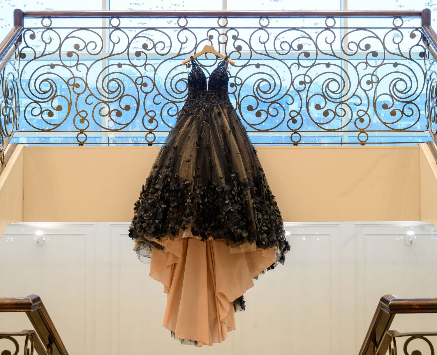 Stunning black gown displayed on hangers with ornate decorative details. Seamill Hydro.