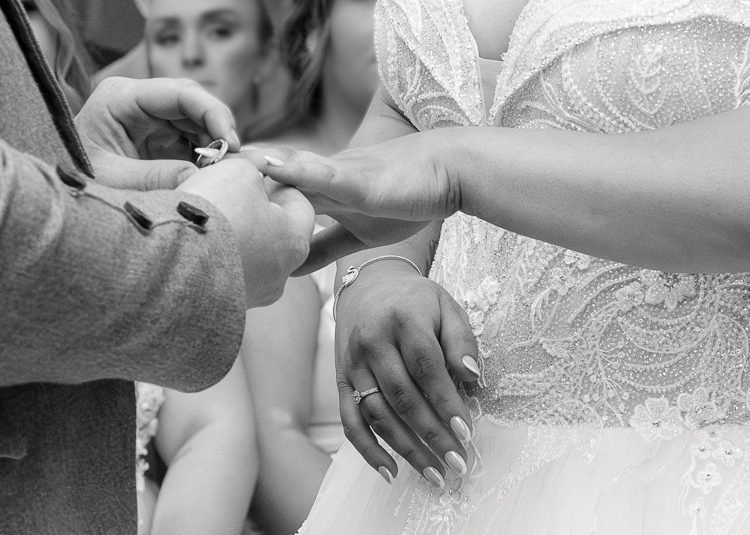 Close-up view of hands with wedding rings exchanging bridal bouquet wrapped in delicate white lace. Hamilton Townhouse