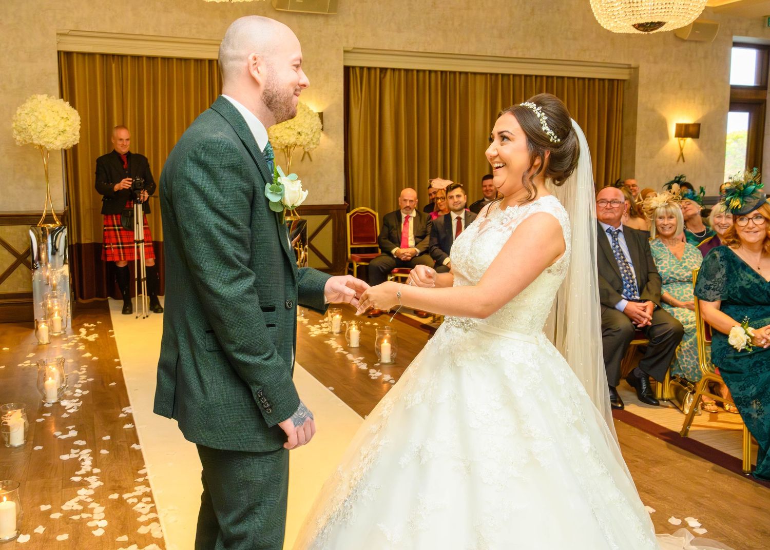 Bride and groom share their first dance at Boclair House, Glasgow with scattered petals on the floor.