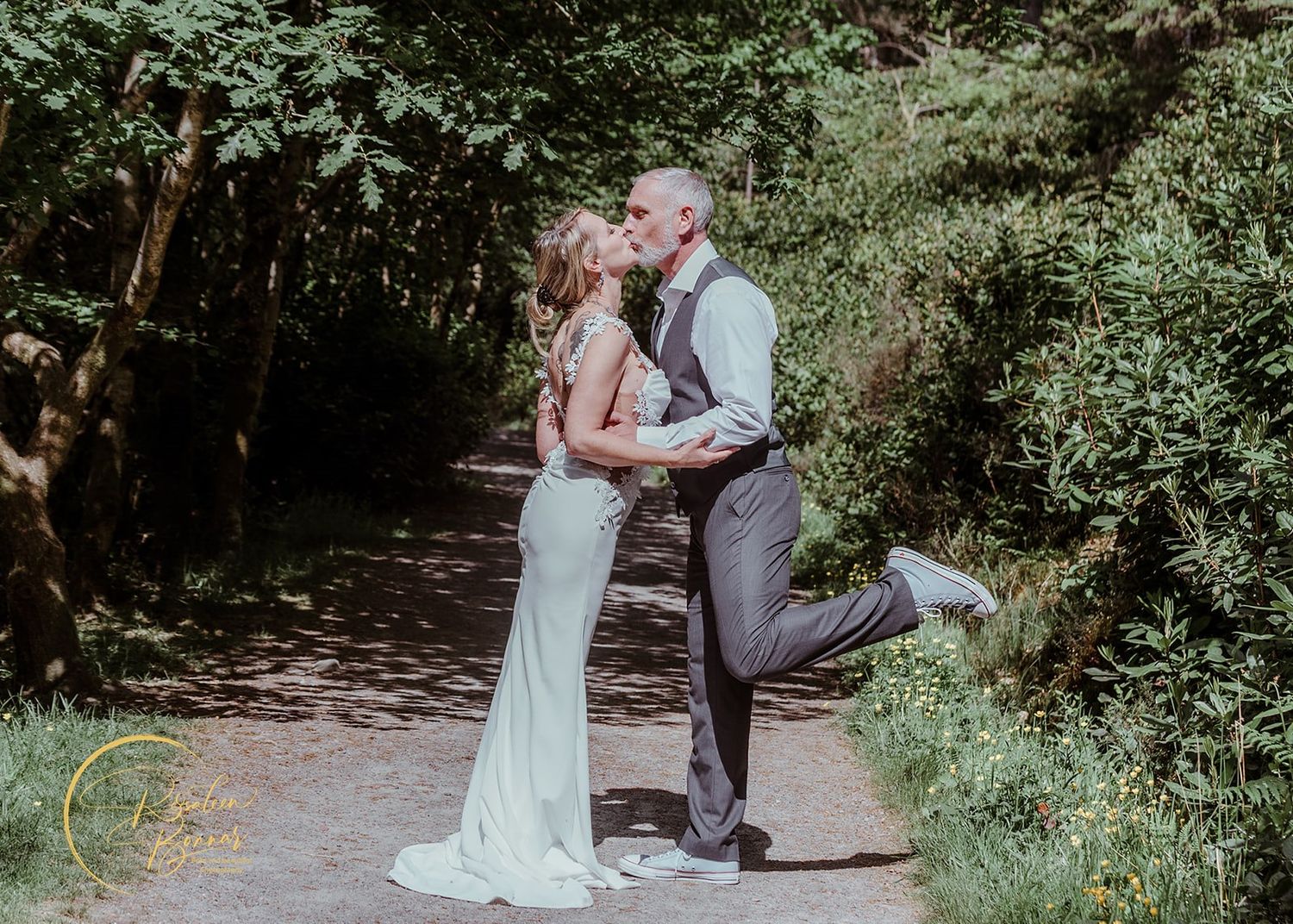 A couple shares intimate moments along a tree-lined path during their wedding photo session. Glencoe