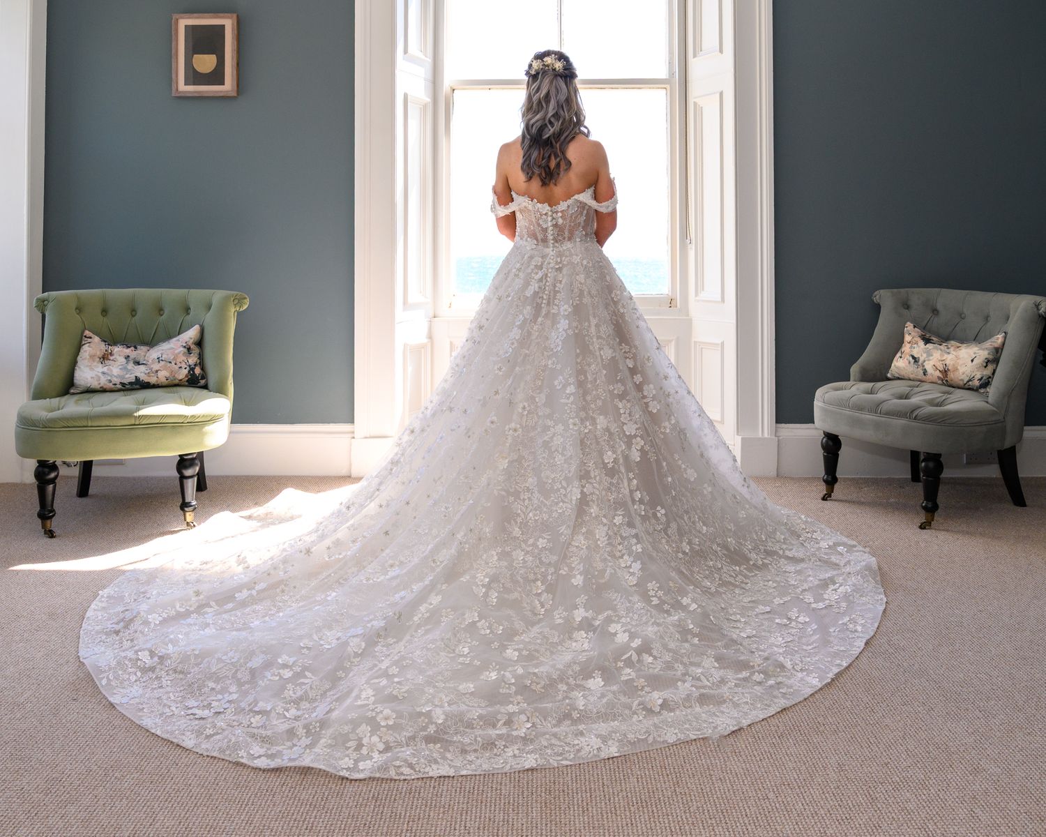 Beautiful white lace wedding dress with long train shown from different angles in an elegant room. Lower Largo