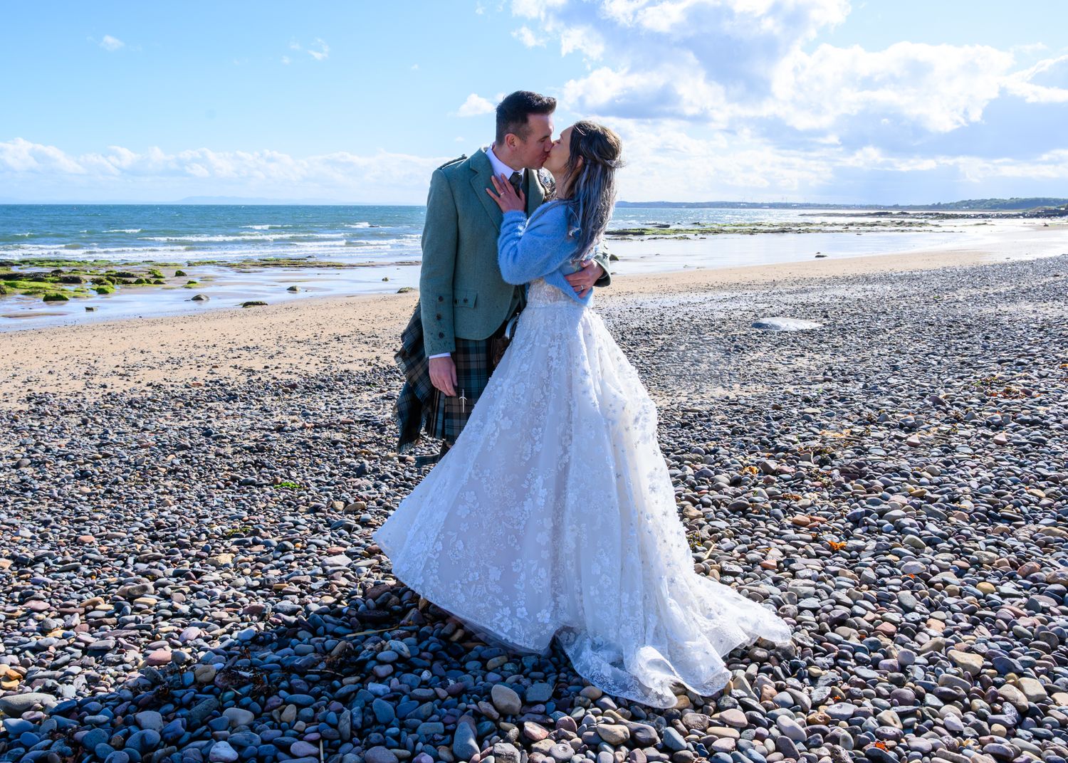 A romantic wedding photo sequence on a rocky beach with waves and blue sky in the background. Lower Largo