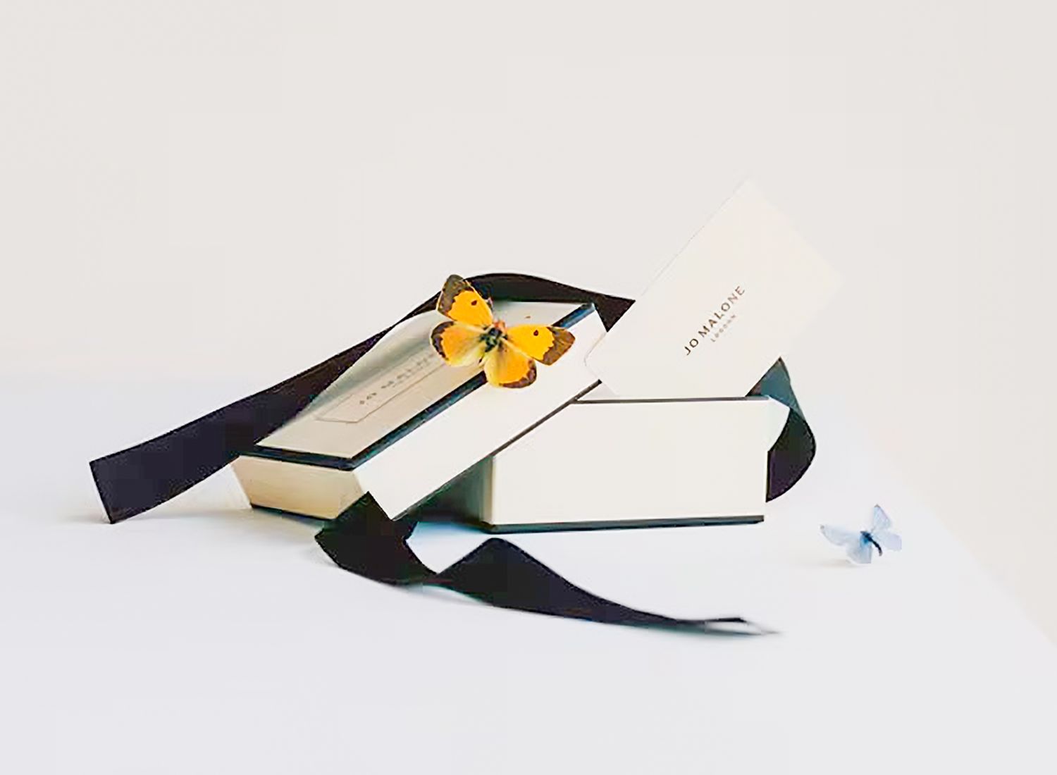 A minimalist paper airplane in white and black colors positioned on a light gray background.