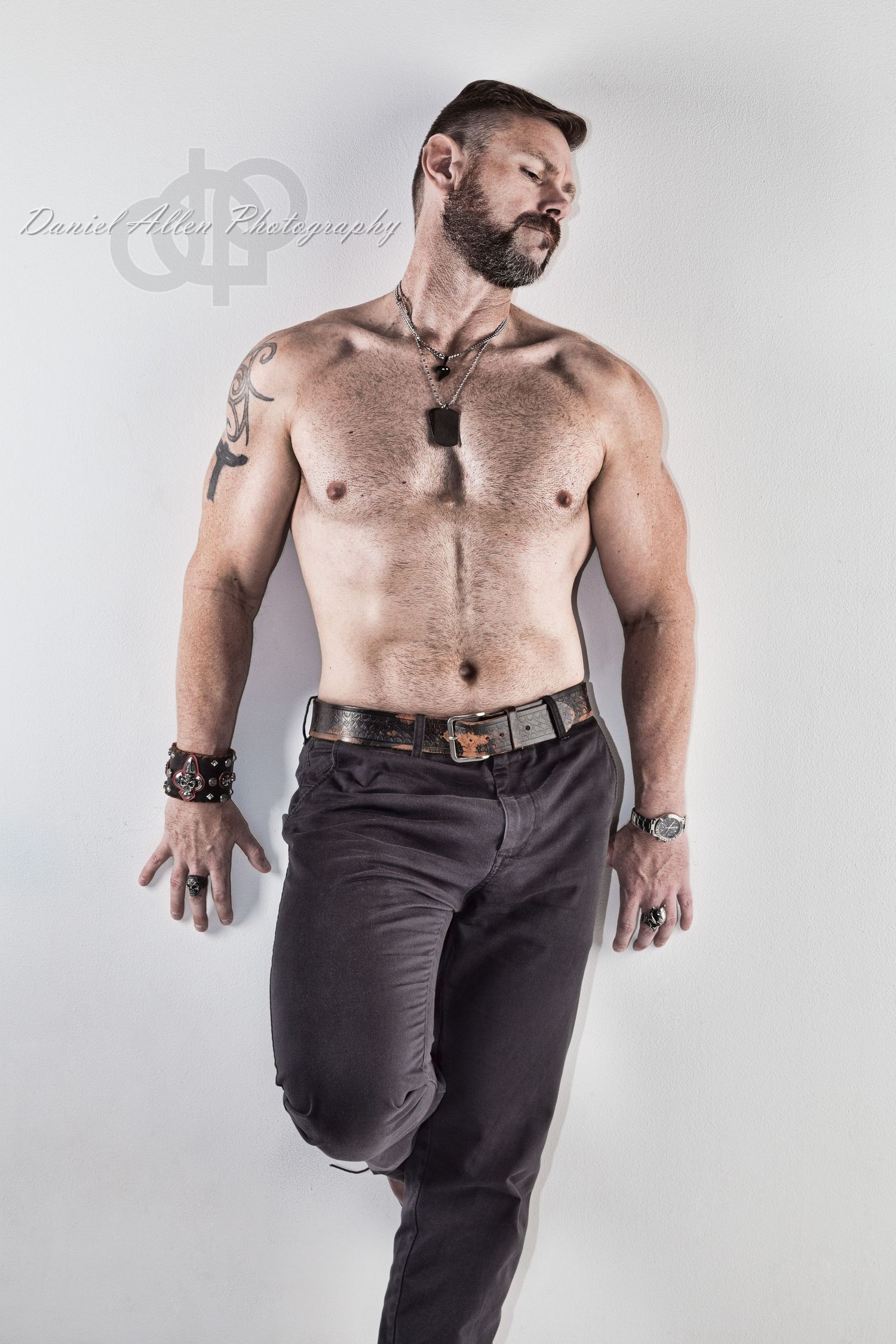 Muscular shirtless figure wearing dark pants strikes dynamic dance poses against light studio background.