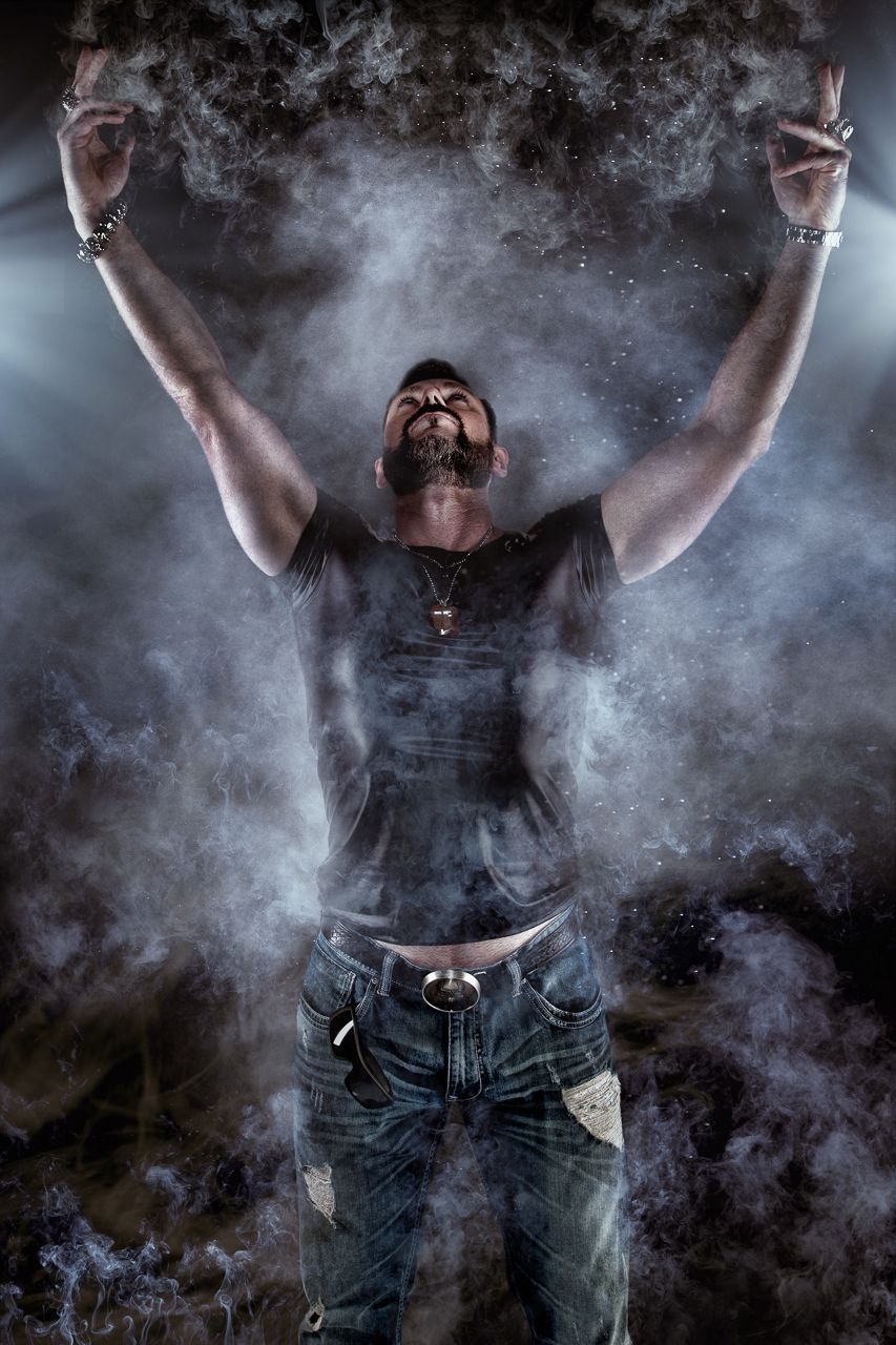 Dramatic black and white photo with smoke effects and silhouetted figure in jeans.
