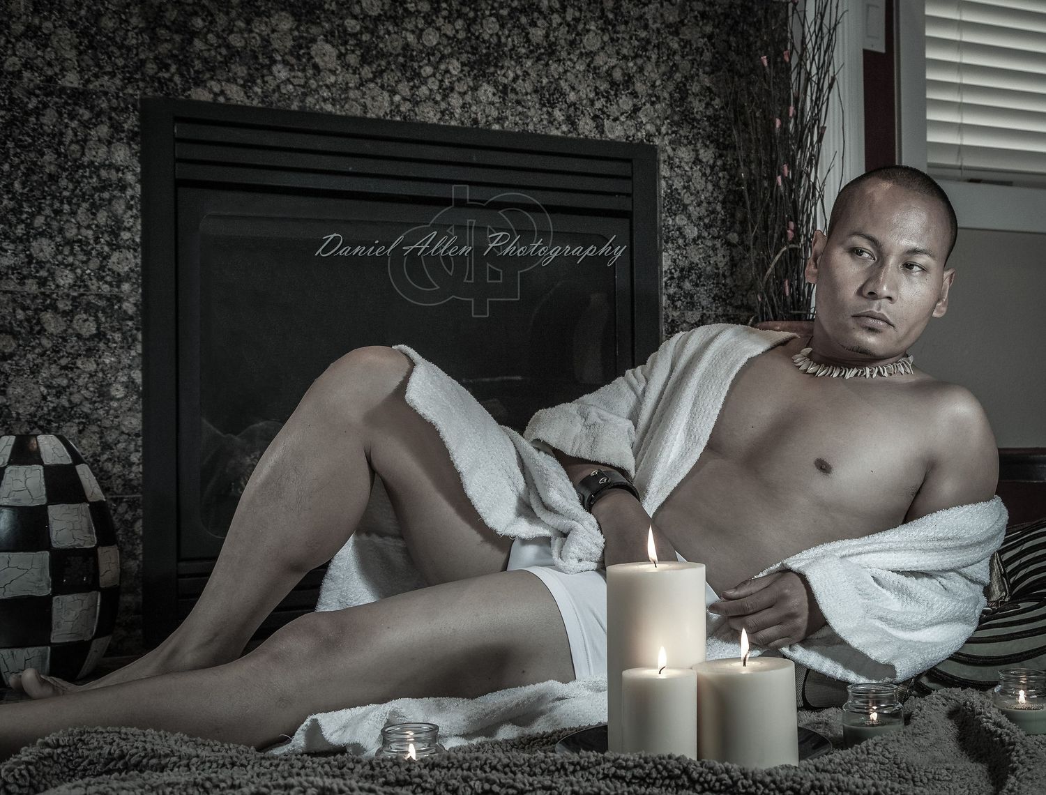 Atmospheric black and white portrait with candlelight creating dramatic contrast against dark background.
