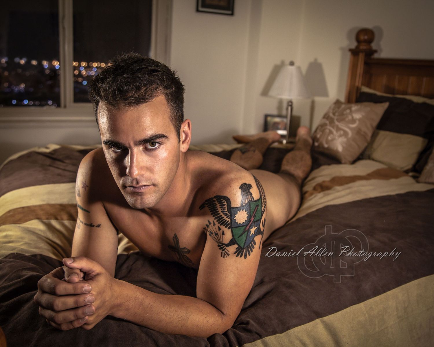 Dramatic bedroom photoshoot with warm lighting and natural poses.