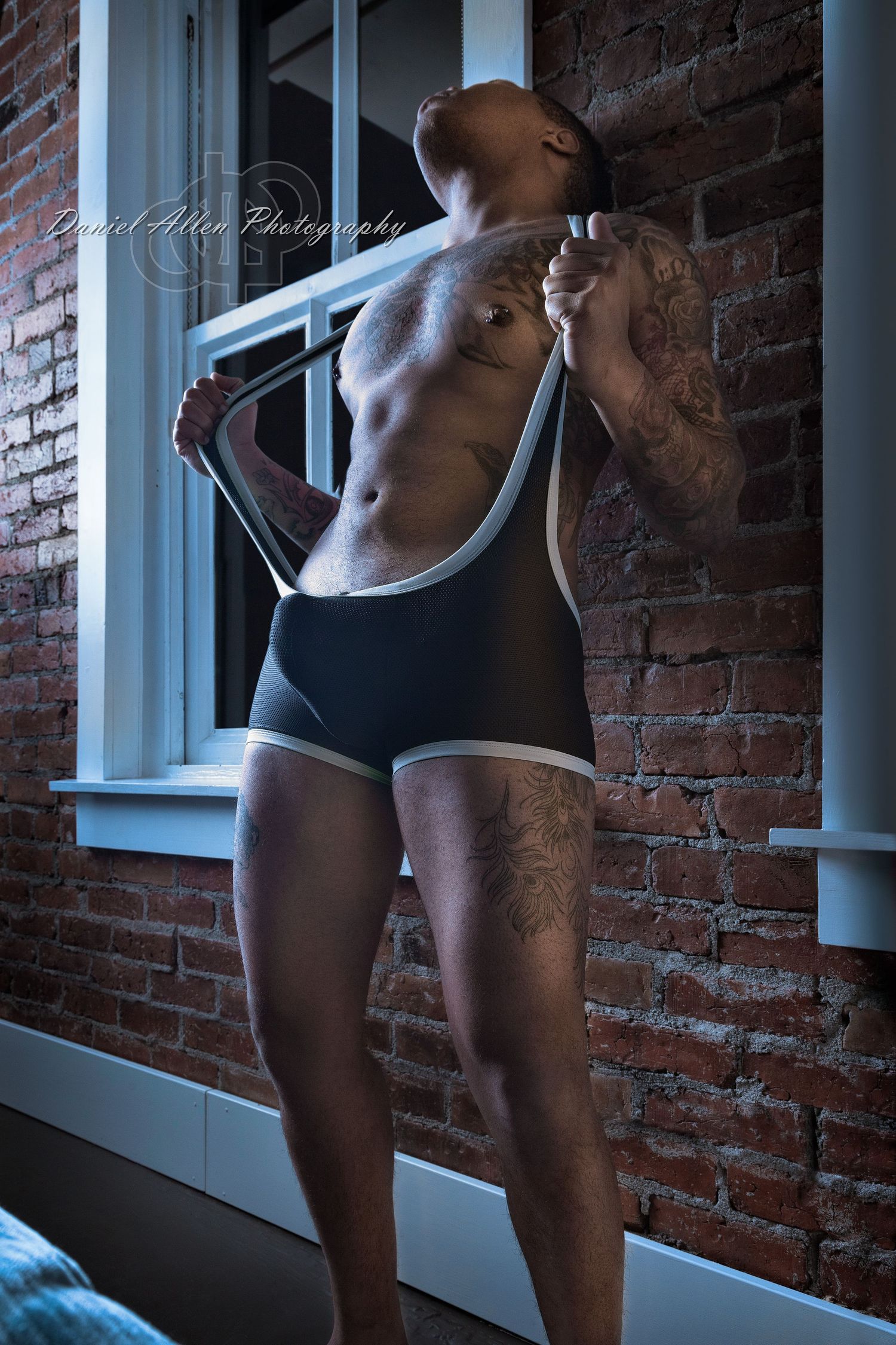 Athletic figures in dark workout attire pose against a brick wall with white window frames in an artistic series.