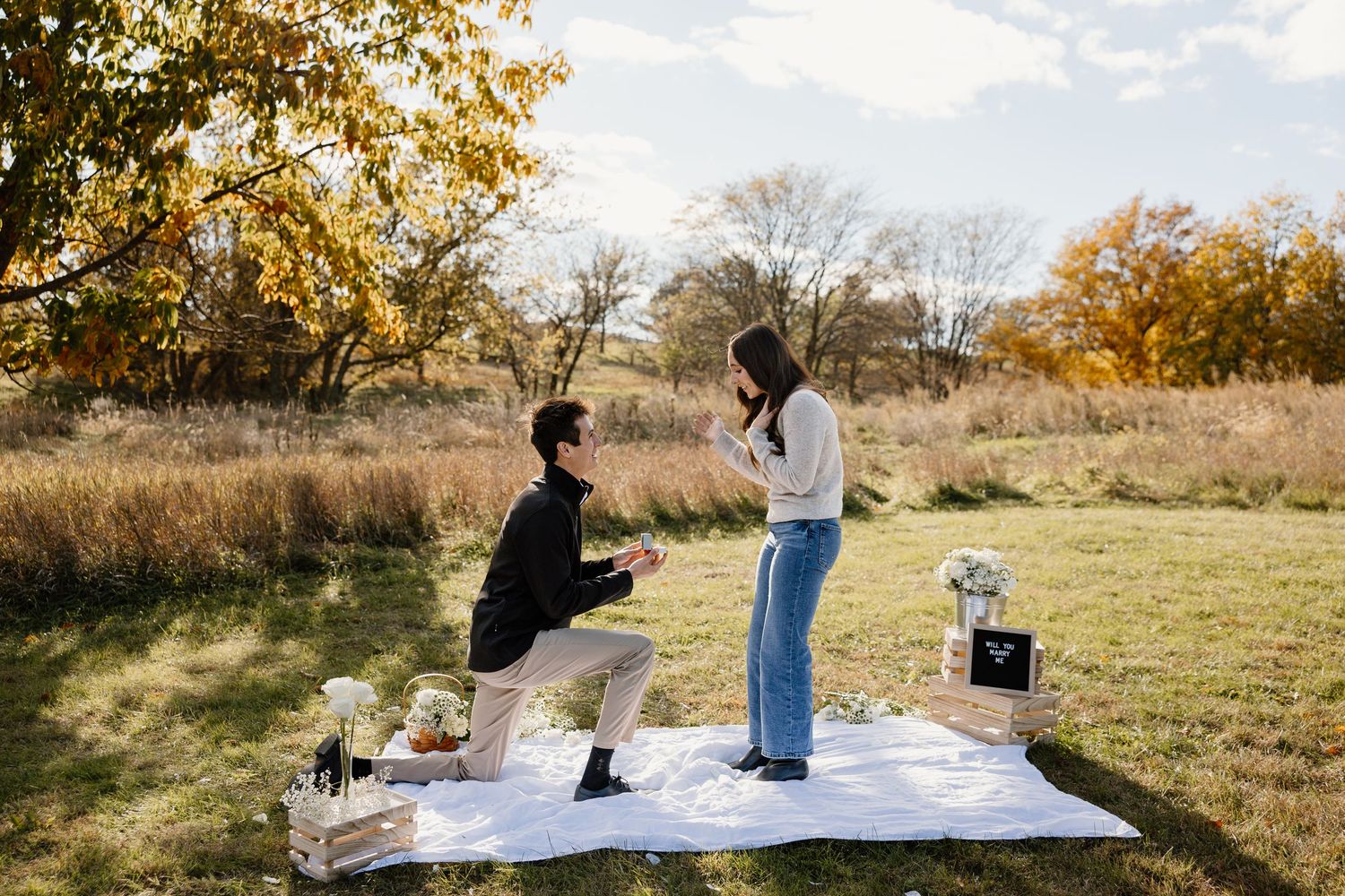 Progressive shots of a surprise proposal moment in a fall meadow setting.