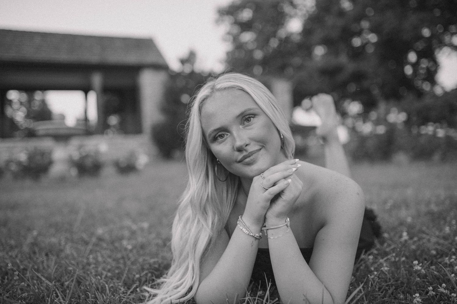 Black and white portrait session in a grassy outdoor setting.