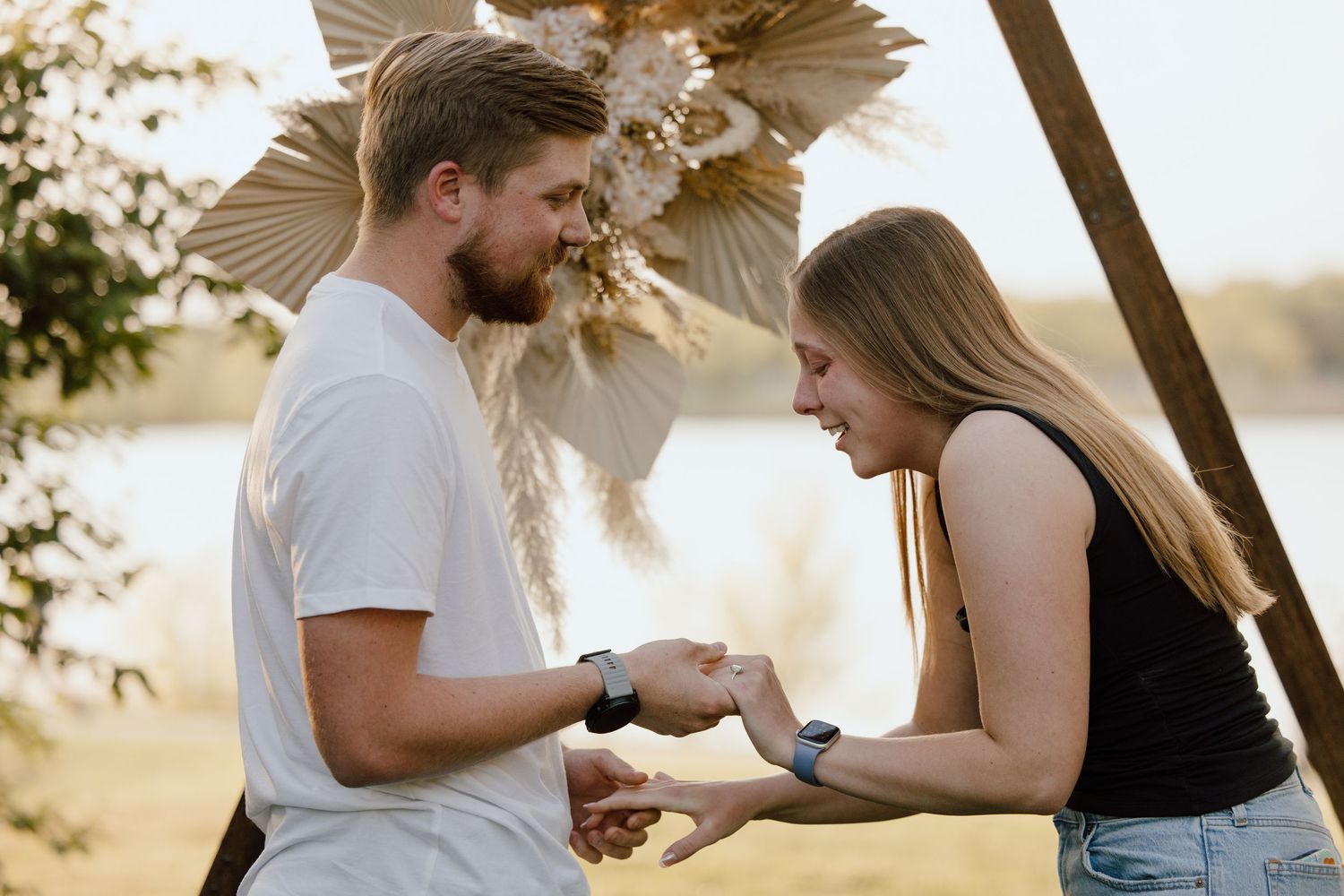 A romantic proposal sequence unfolds in a natural outdoor setting at sunset.