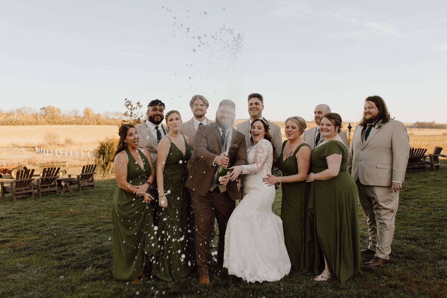 Wedding party gathered outdoors during golden hour celebration.