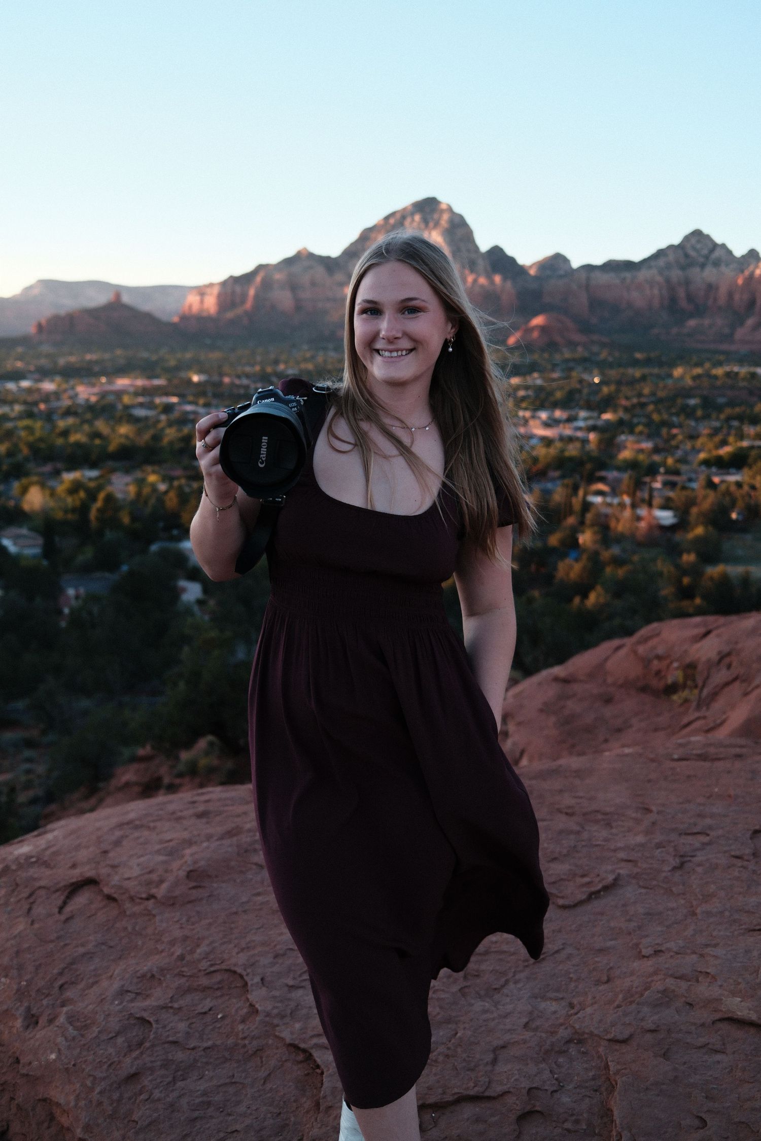 Photography session on red rocks overlooking desert mountains at golden hour.