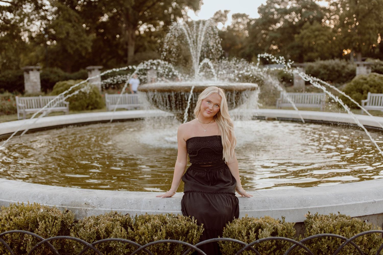 A sunset portrait by an ornate fountain in a garden setting.
