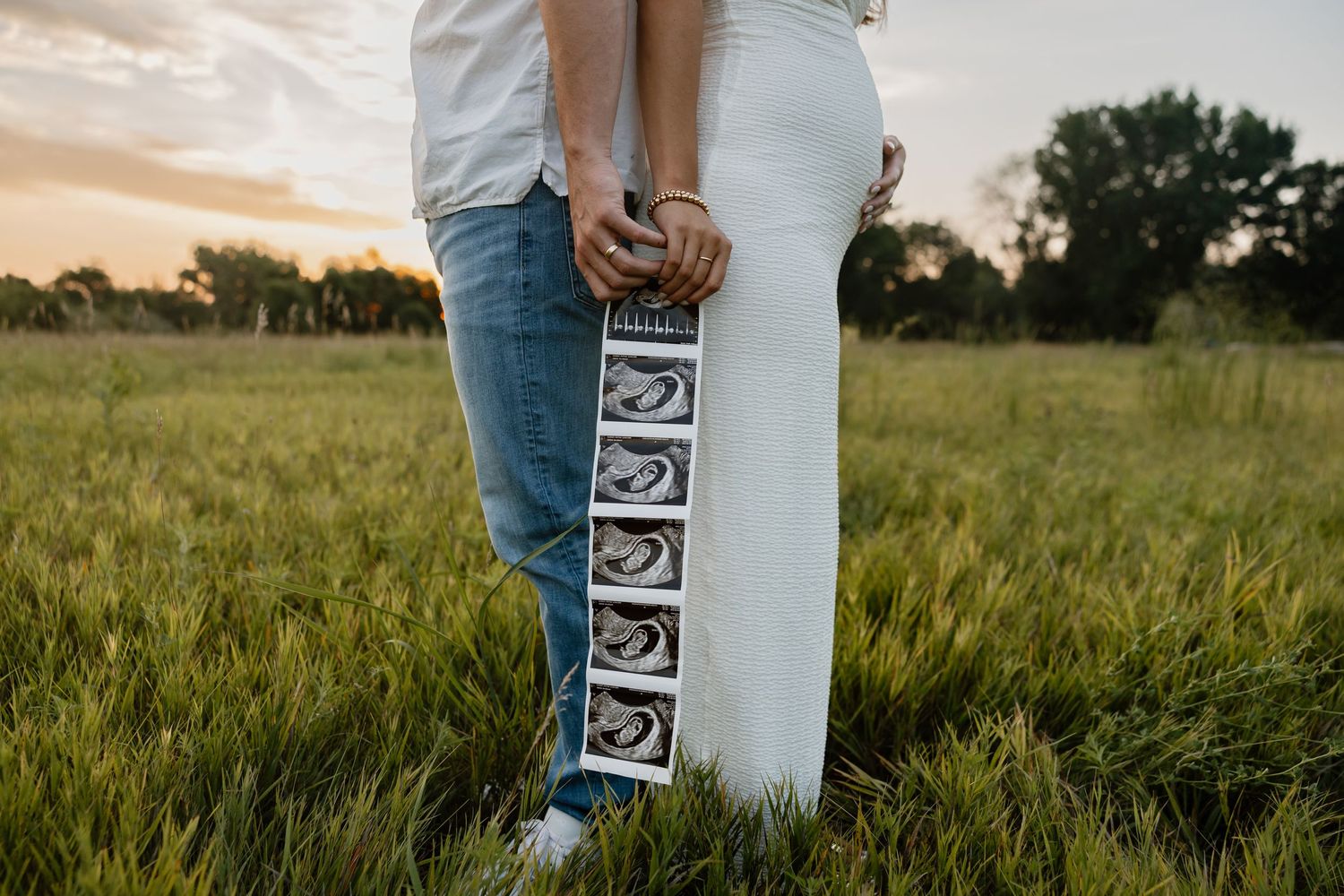 Series of pregnancy announcement photos showing ultrasound images in a sunny field.