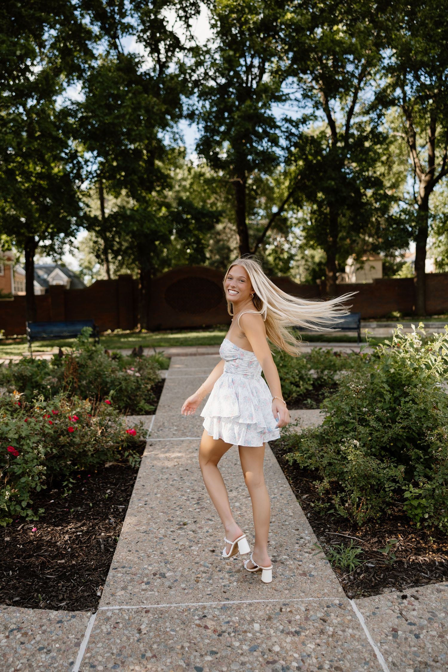 Playful dance movements captured in a garden setting with stone pathways and greenery.