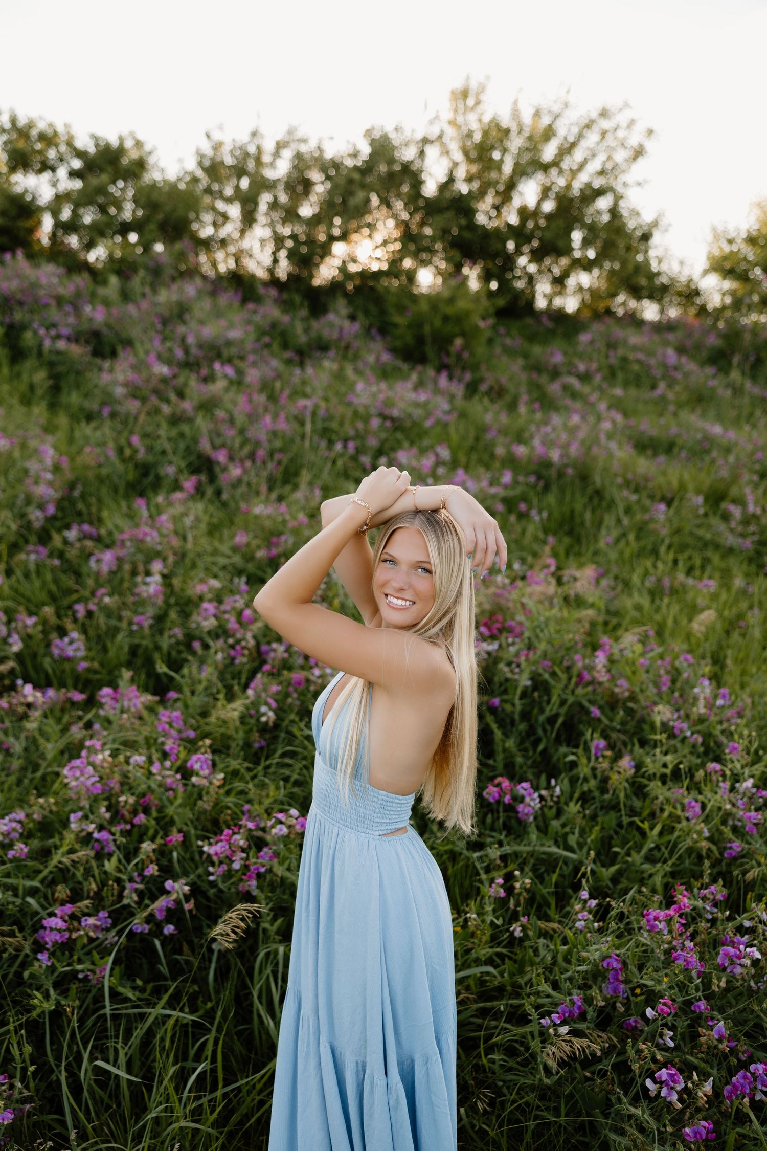Light blue sundress photoshoot among purple wildflowers at golden hour.