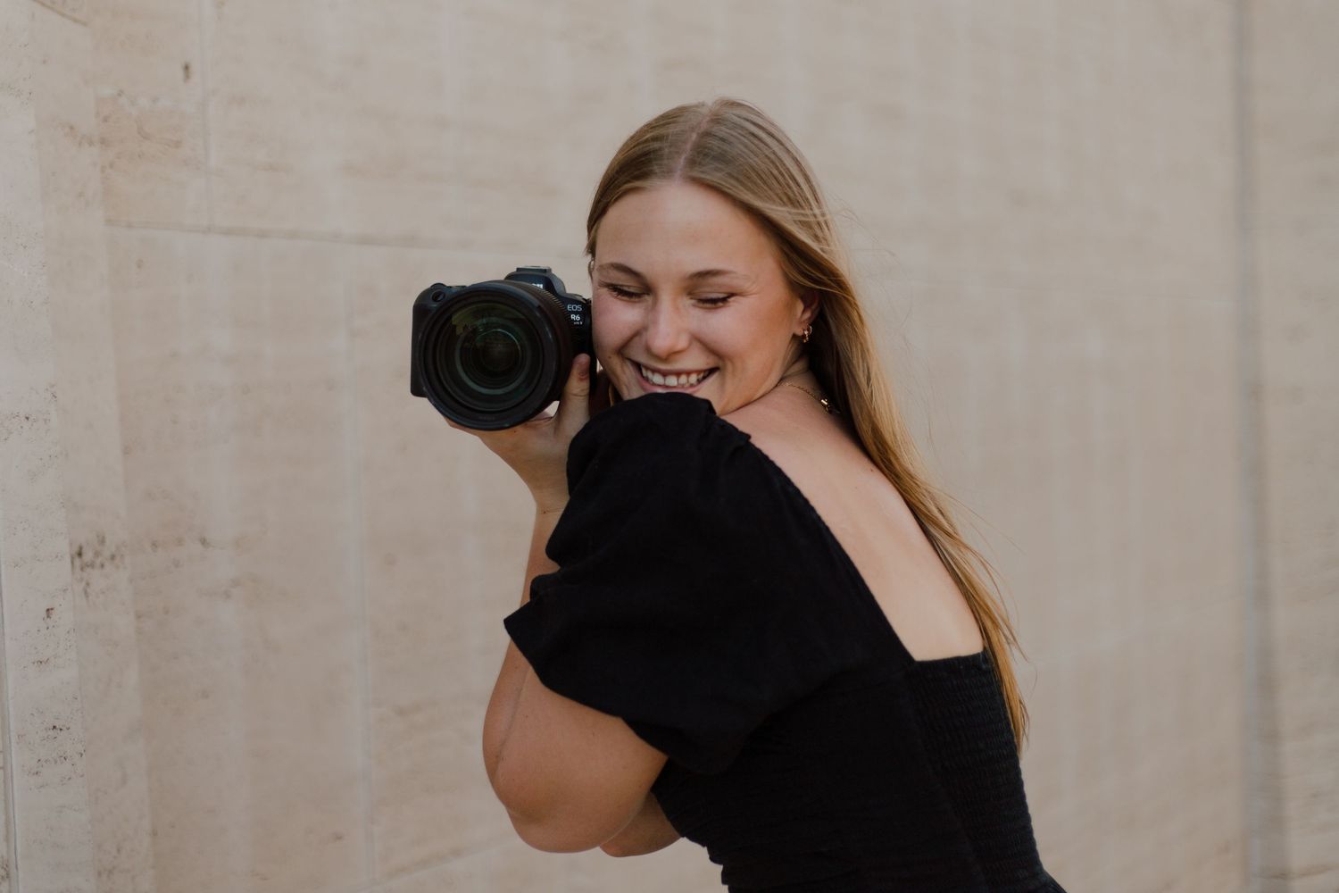 Professional photographer with camera taking portraits in a studio setting.