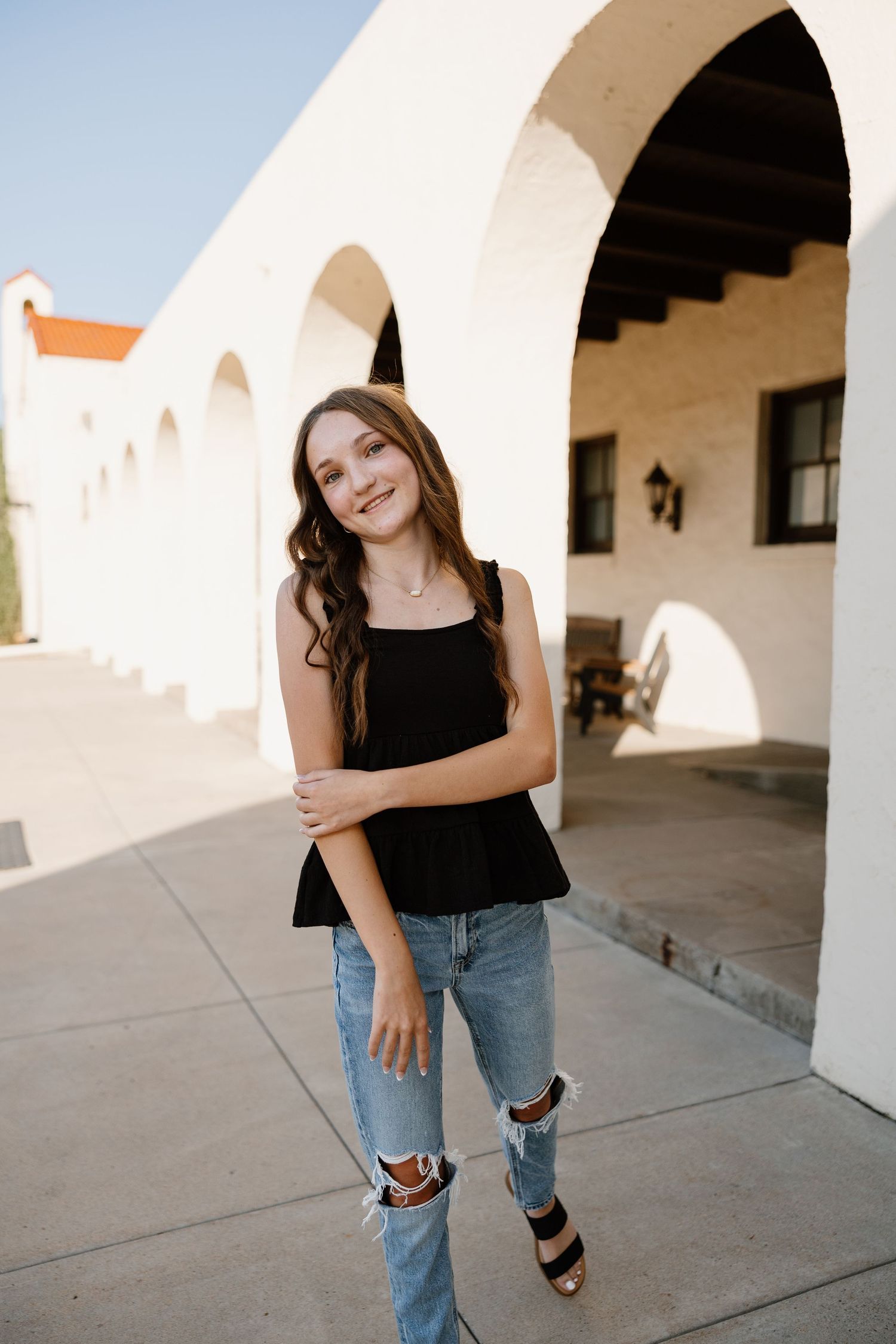 Casual fashion poses against white arched architecture and concrete floors.