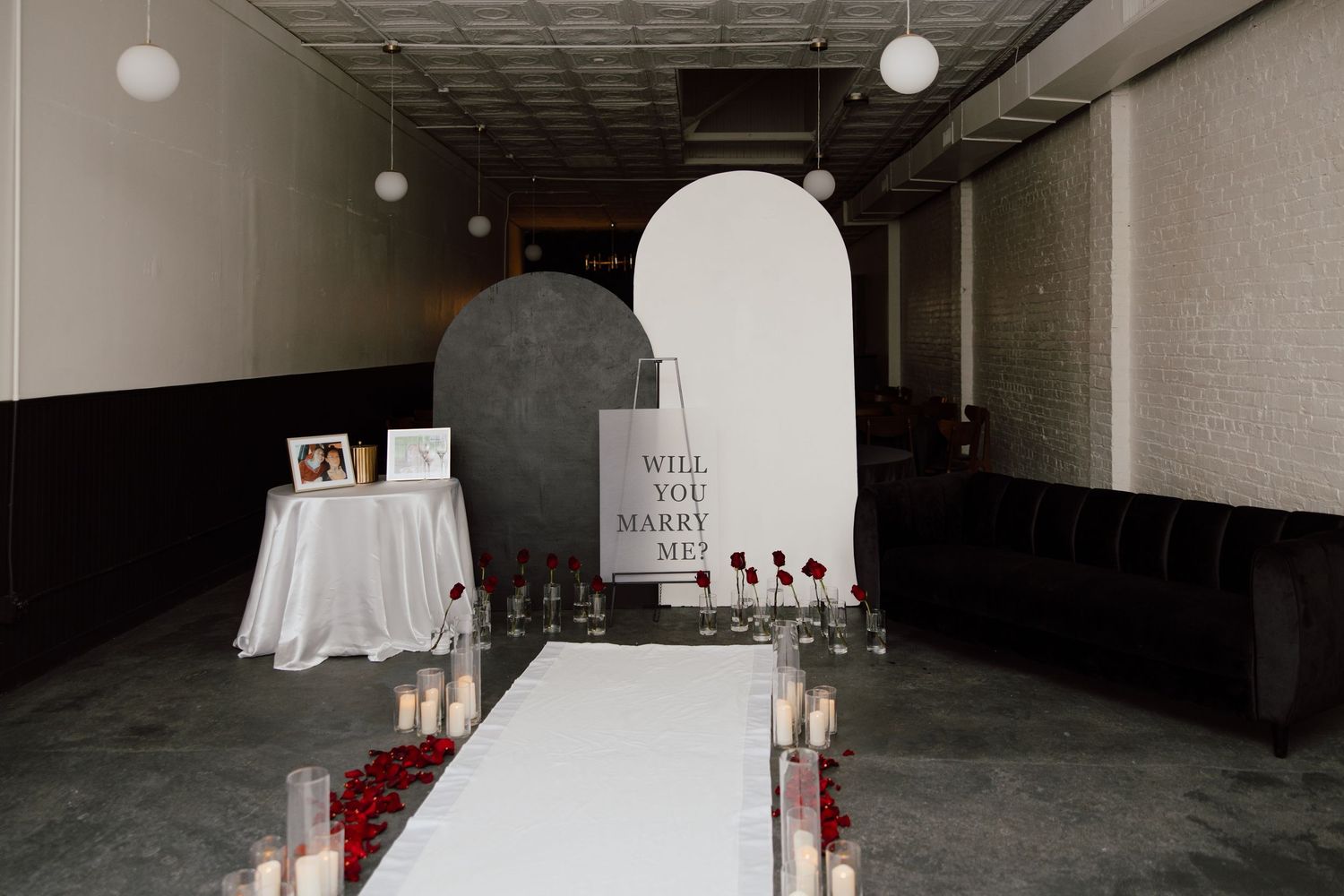Dark indoor space decorated with white paper lanterns and romantic lighting.