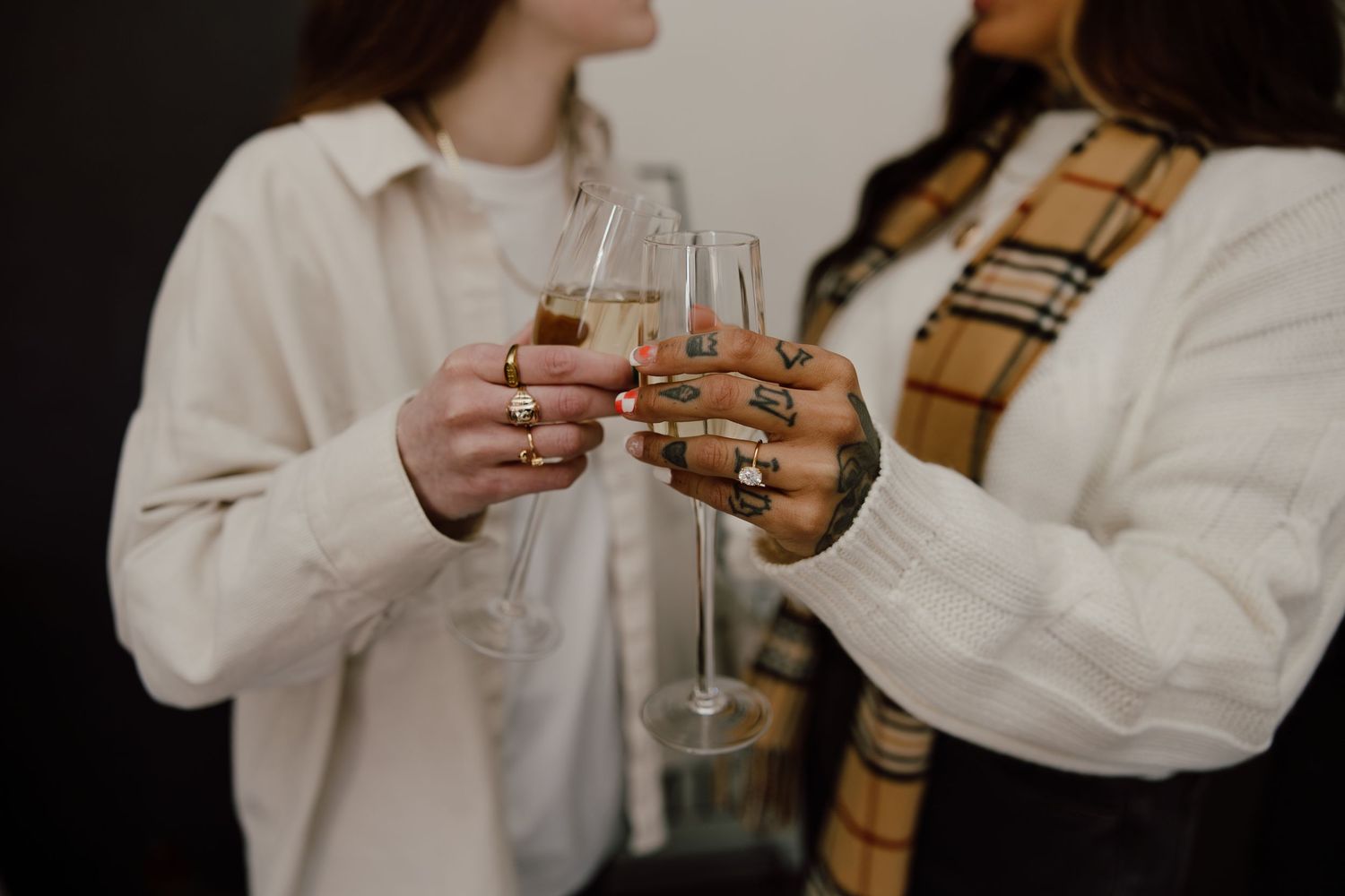 People holding champagne glasses celebrate together in a minimalist setting.