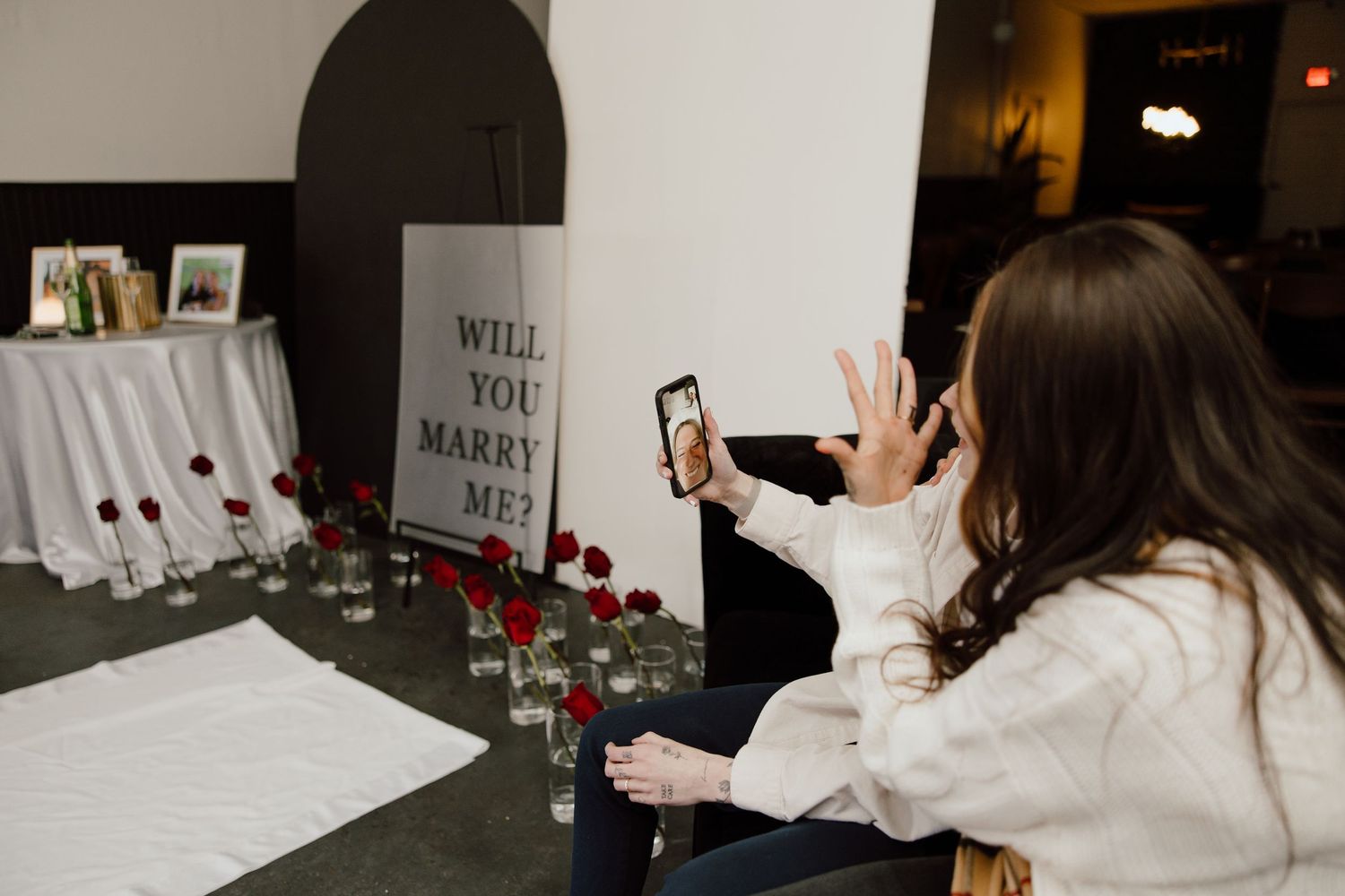 People sharing joyful moments in a modern event space with wall decorations.