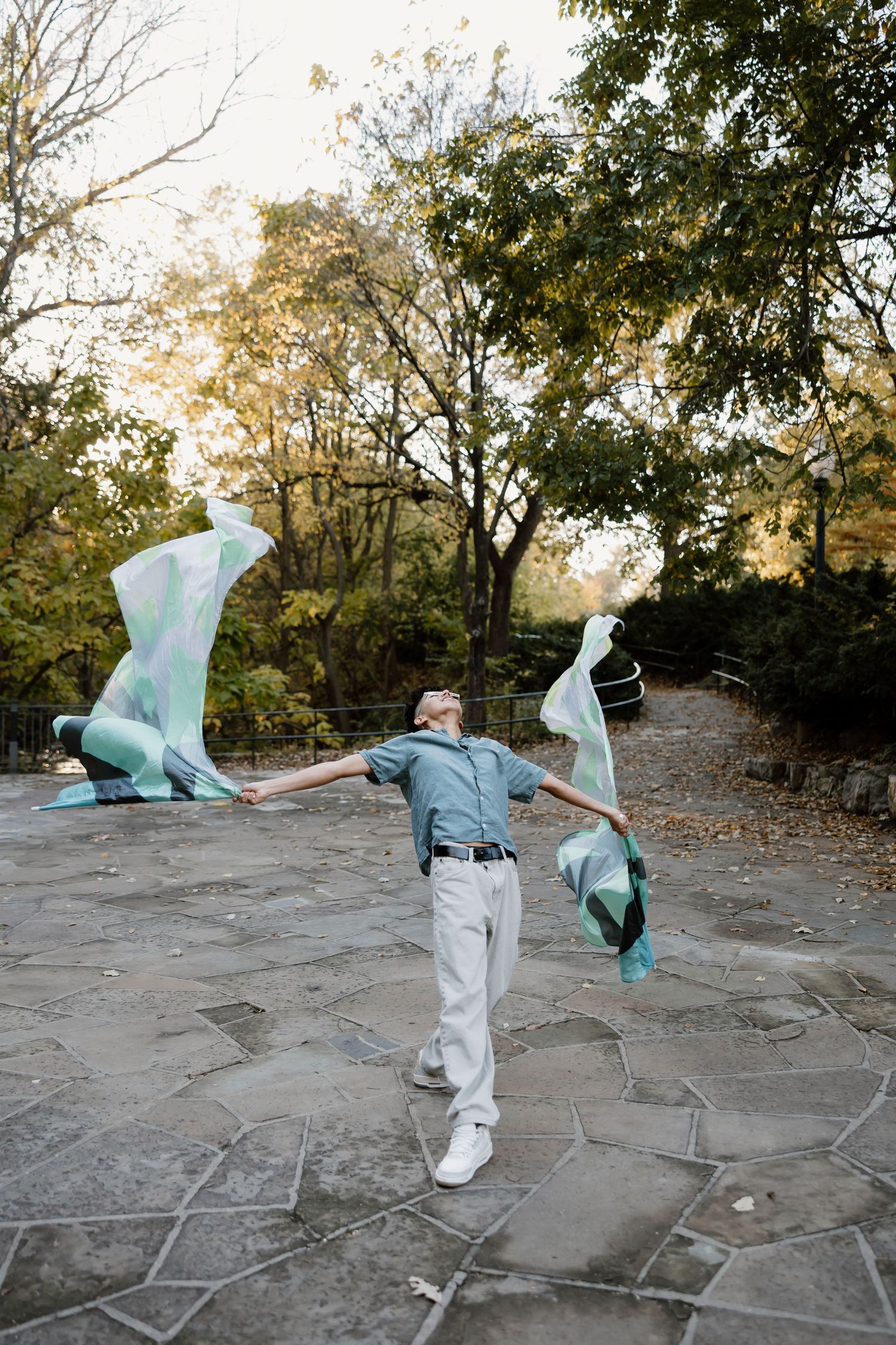 A sequence of photos shows someone in white clothing dancing with a flowing light blue fabric in an outdoor setting.